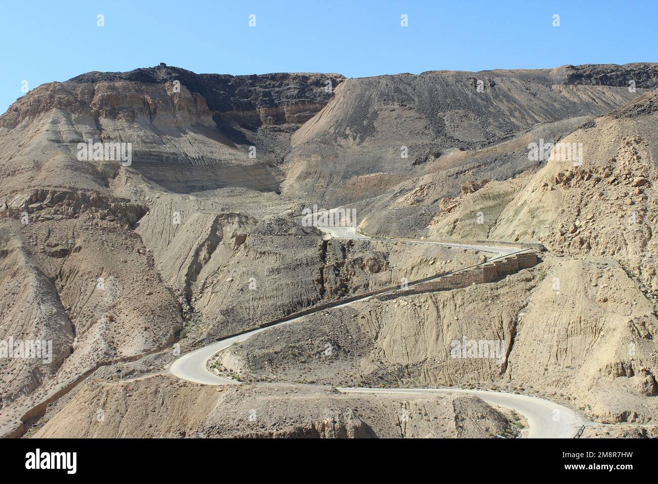 Jordan - gewundene Wüstenstraße des Kings Highway, die in den Wadi Mujib Canyon führt Stockfoto