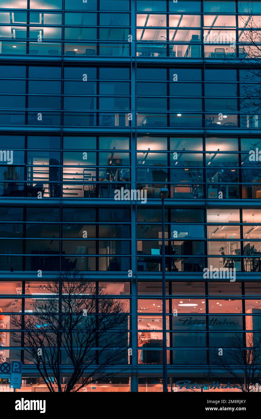 Ein vertikales Bild von der Fassade eines modernen Glasgebäudes in München, Bayern Stockfoto