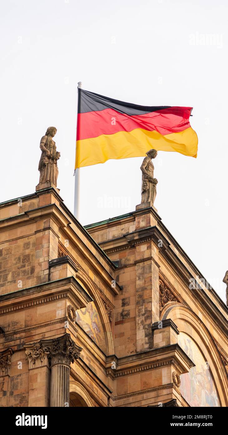 Ein vertikales Bild der deutschen Flagge auf dem historischen Gebäude in München, Bayern Stockfoto