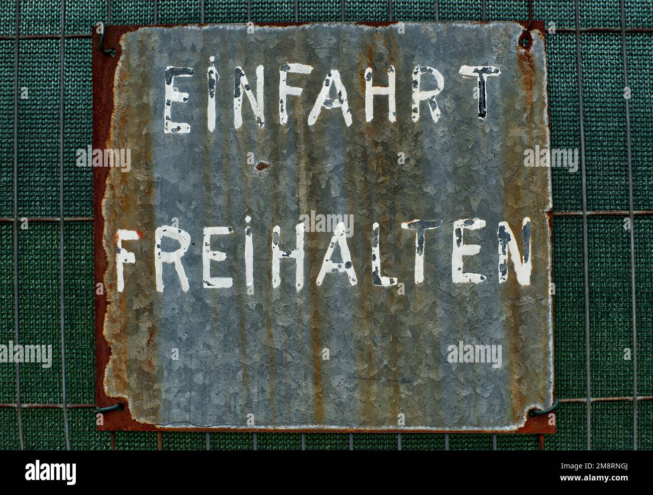 Altes rostiges Blechschild in deutscher Schrift „Einfahrt freihalten“ bedeutet „Eingang muss frei gehalten werden“ Stockfoto