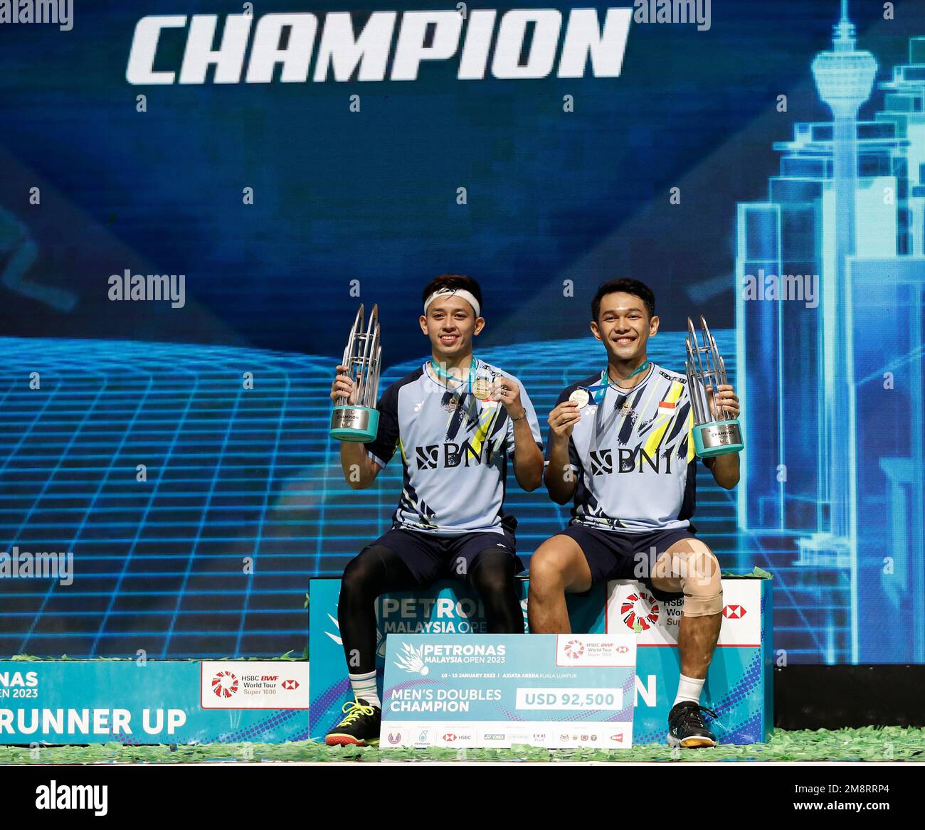 Kuala Lumpur, Malaysia. 15. Januar 2023. Fajar Alfian (R) und Muhammad Rian Ardianto aus Indonesien posieren mit ihren Medaillen auf dem Podium, nachdem sie Liang Wei Keng und Wang Chang aus China während des Finalspiels der Men Doubles der Petronas Malaysia Open 2023 in der Axiata Arena besiegt hatten. Fajar Alfian und Muhammad Rian Ardianto aus Indonesien gewannen damit Punkte; 21/18/21 : 18/21/13 Kredit: SOPA Images Limited/Alamy Live News Stockfoto