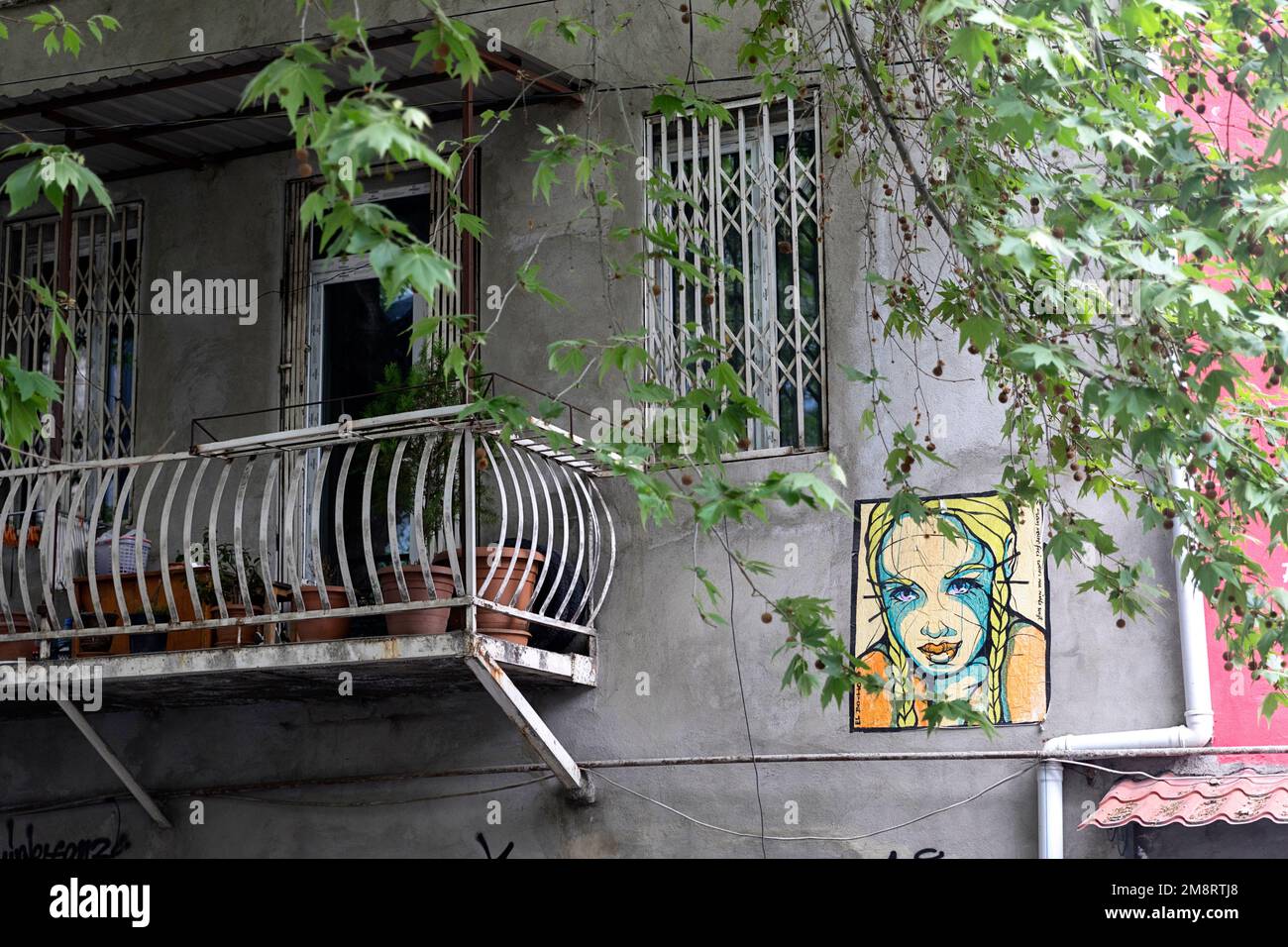Ein farbenfrohes Street-Art-Fresko, das auf der riesigen Fassade eines Wohngebäudes gemalt ist, zeigt die lebendige urbane Kunstszene in Tbilissi, Georgien. Stockfoto