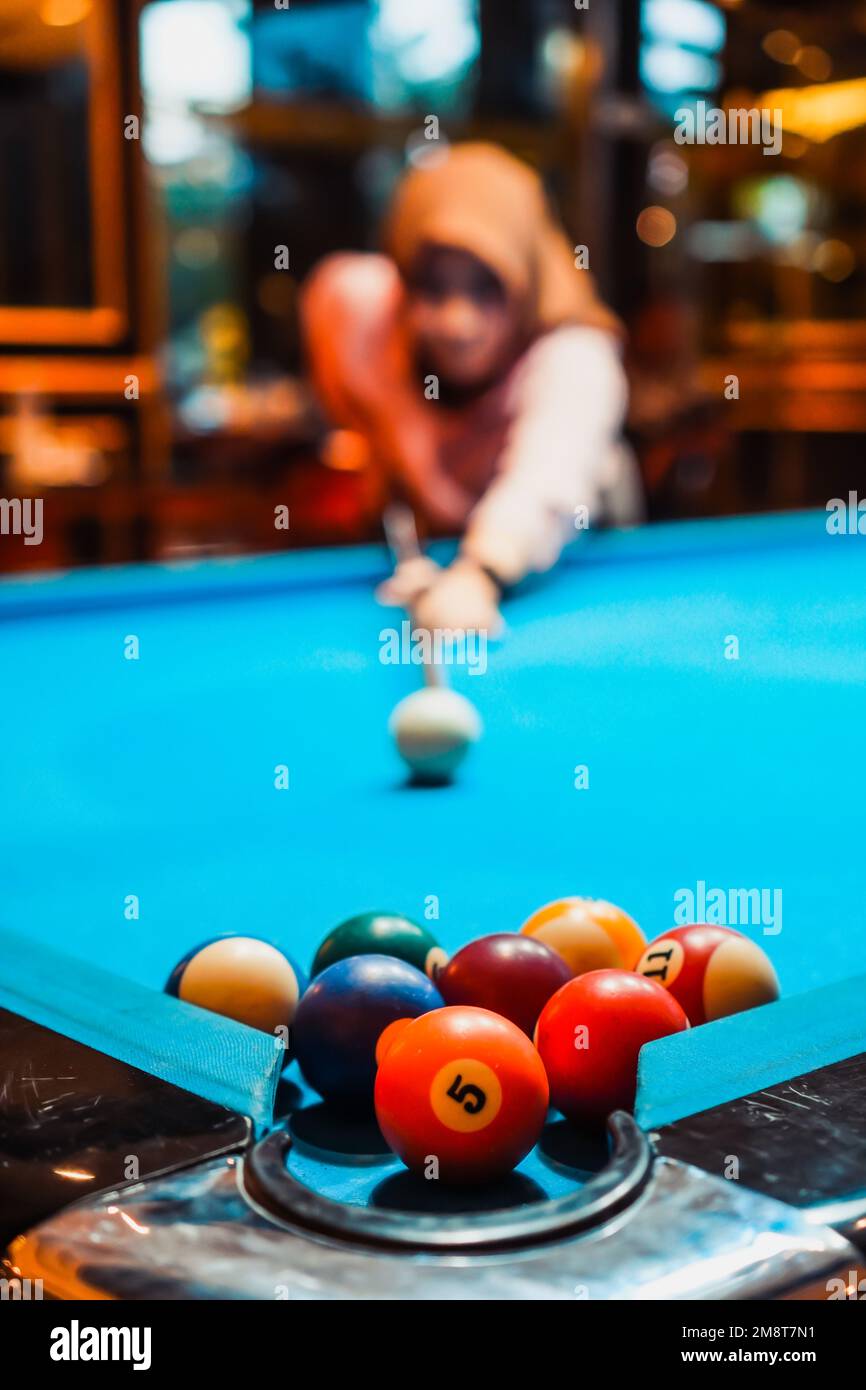 Hidschab-Frauen und die besten Schießpositionen im Billardspiel. Porträtfoto Stockfoto