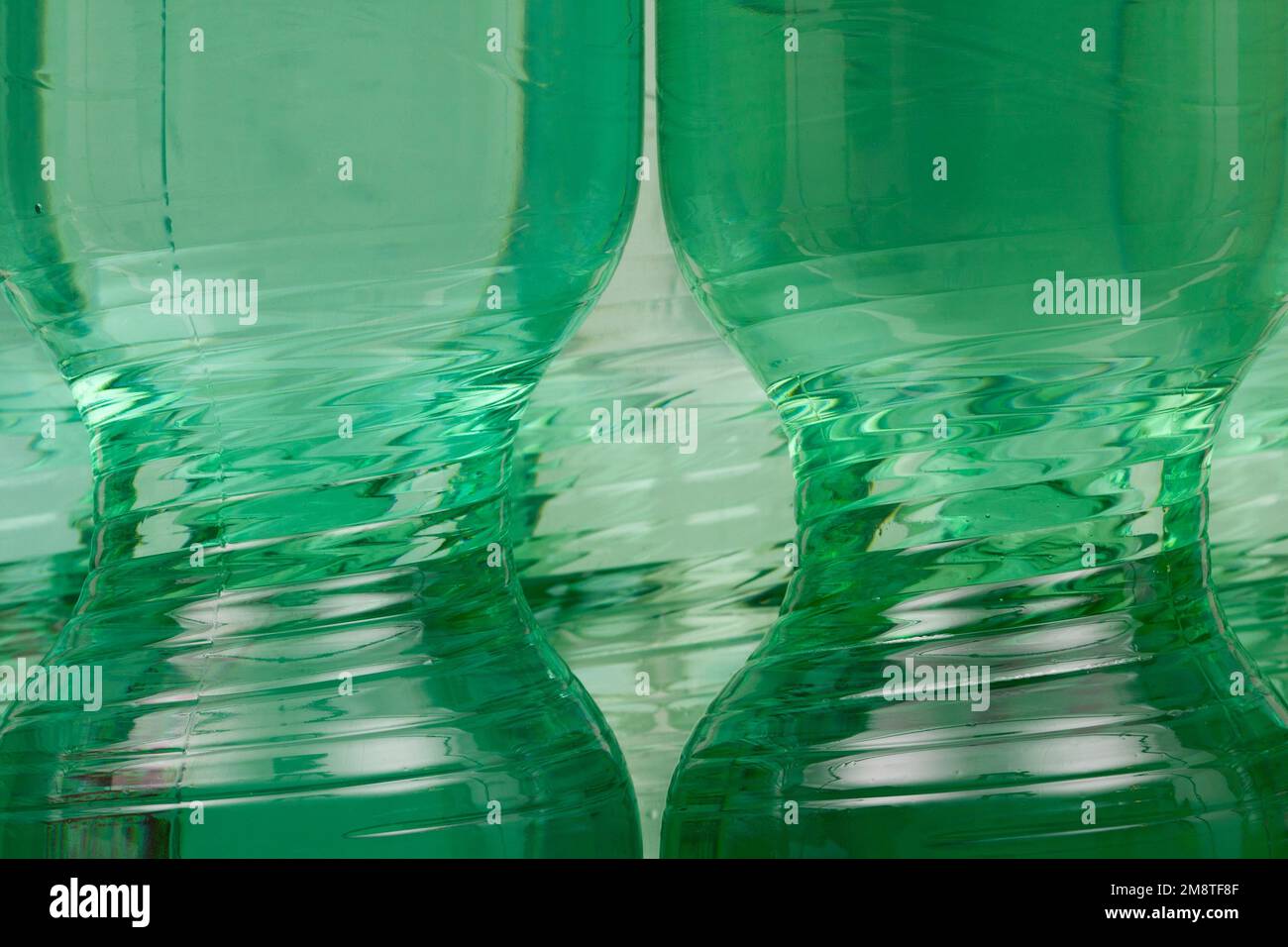 Zeitlose Schönheit einer Kunststoffflasche in leuchtendem Grün. Der schlanke Mittelteil einer Plastikflasche. Stockfoto