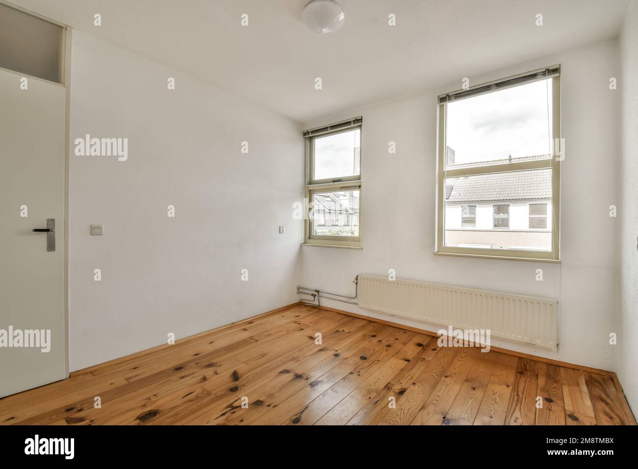 Ein leeres Zimmer mit Holzfußboden und weißen Wänden im Zimmer ist sehr sauber, aber es gibt kein Licht Stockfoto