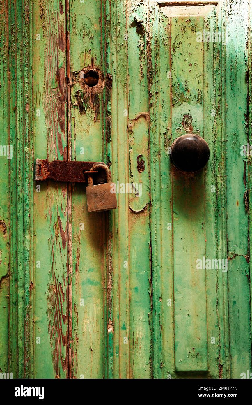 Rostiges Türschloß mit Riegel, an verwitterter Holztür mit grünem Farbresten, Valletta, Malta, Europa Stockfoto