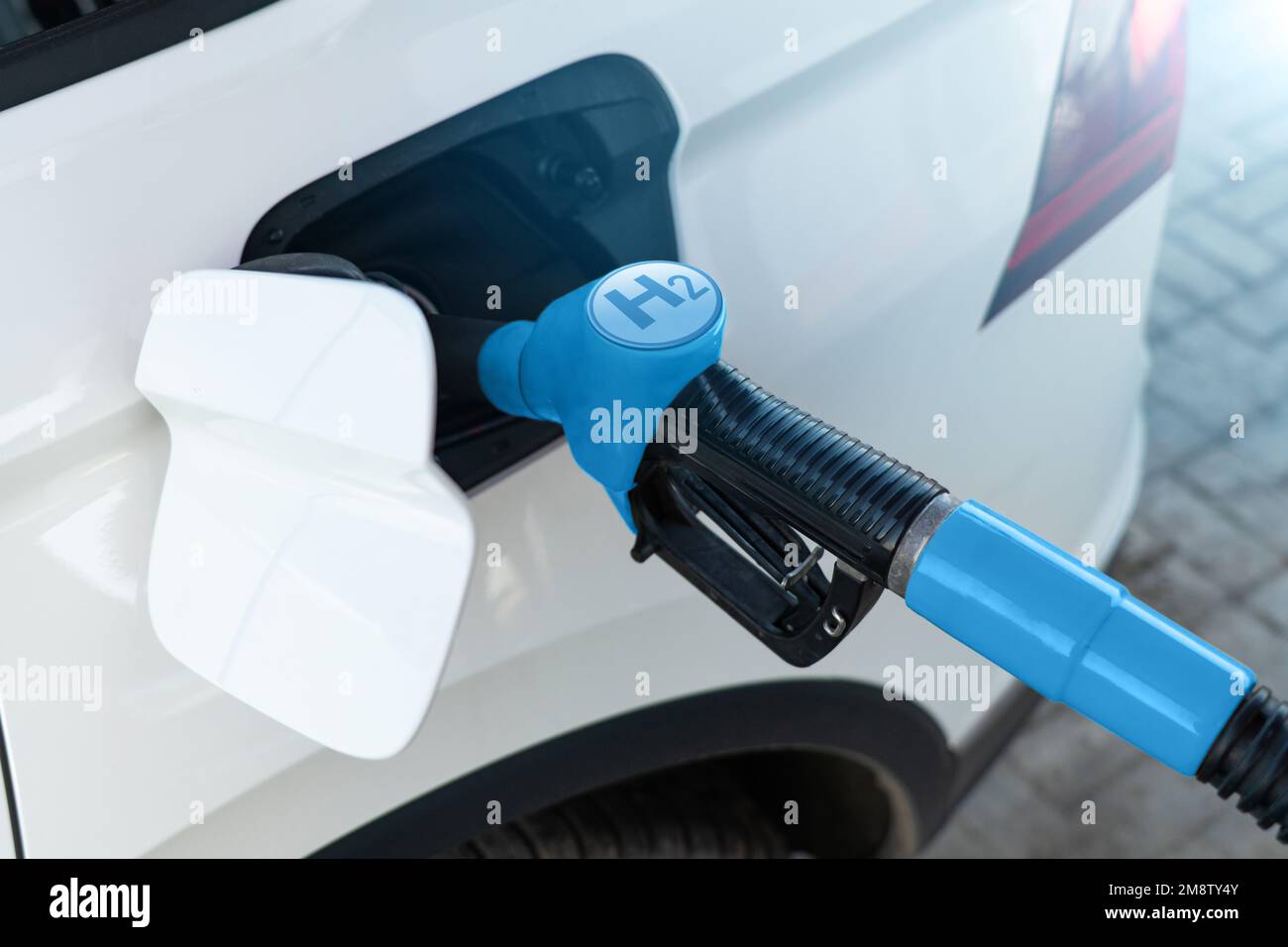 Ein Mann treibt ein Auto mit Wasserstoff an. Sauberes Transportkonzept Stockfoto