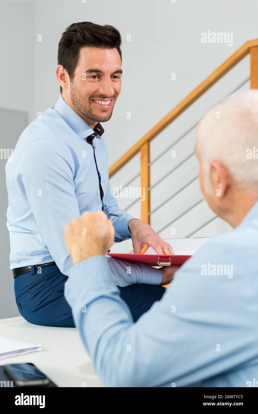 Leitender Angestellter und jüngerer, der im Büro spricht Stockfoto