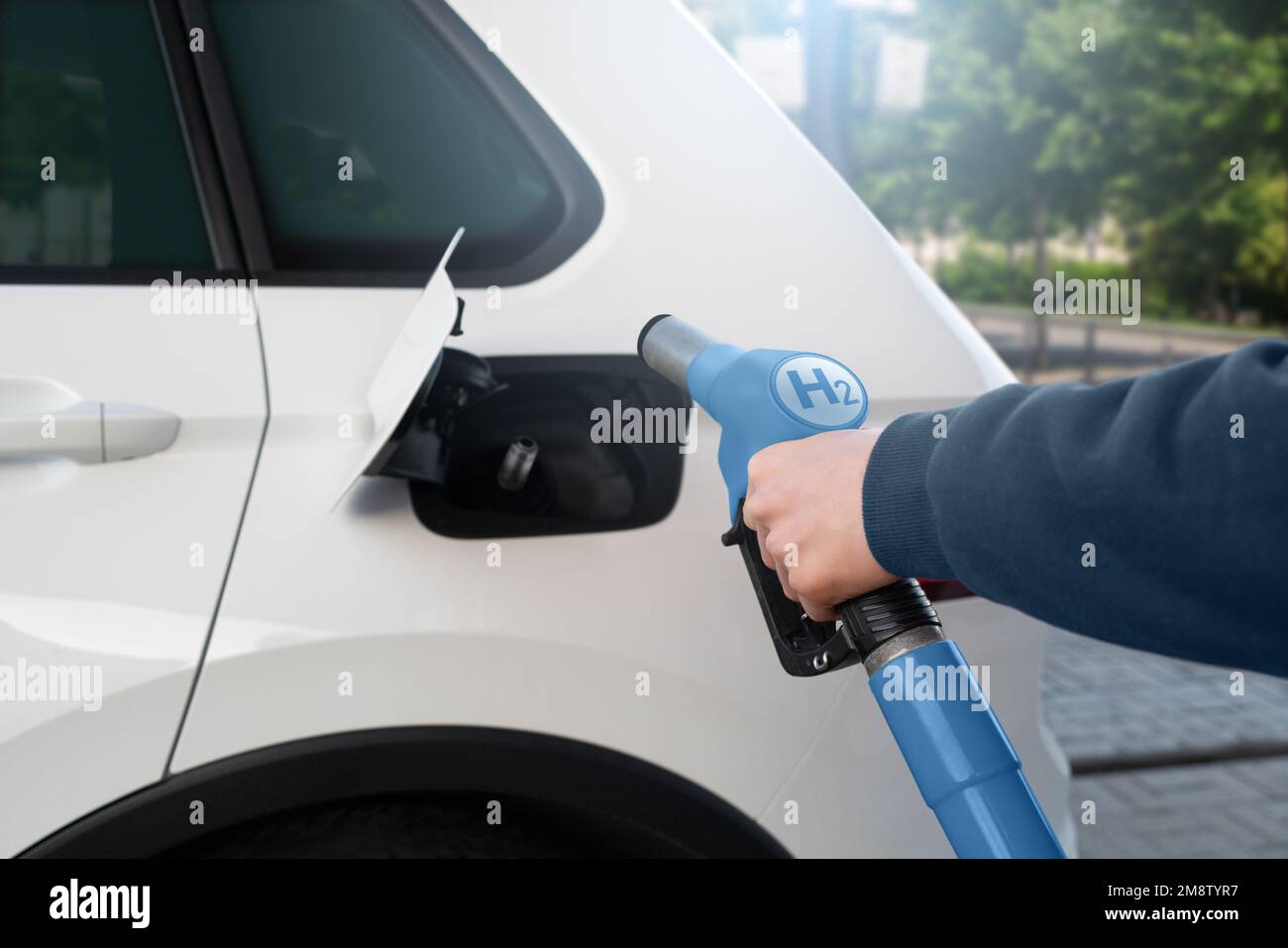 Ein Mann treibt ein Auto mit Wasserstoff an. Sauberes Transportkonzept Stockfoto