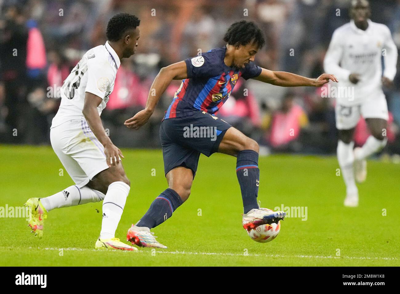Barcelona's Jules Kounde in action in front of Real Madrid's Vinicius Junior during the final of the Spanish Super Cup between Barcelona and Real Madrid in Riyadh, Saudi Arabia, Sunday, Jan. 16, 2023. (AP Photo/Hussein Malla) Stockfoto