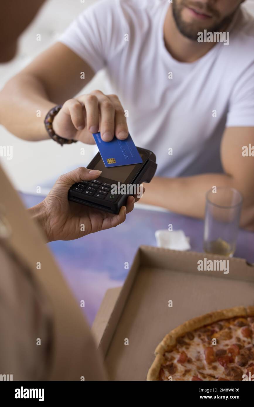 Männlicher Gast mit Kreditkarte im Café, bezahlt für das Essen Stockfoto