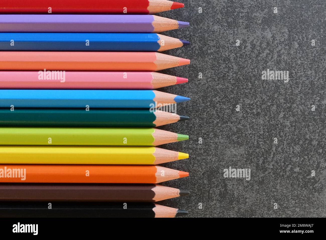 Malstifte in vielen verschiedenen Farben und mit strukturiertem Hintergrund mit Platz zum Kopieren Ihres Textes. Stockfoto