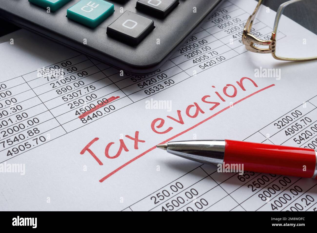 Handgeschriebenes Schild zur Steuerhinterziehung auf den Finanzdaten. Stockfoto
