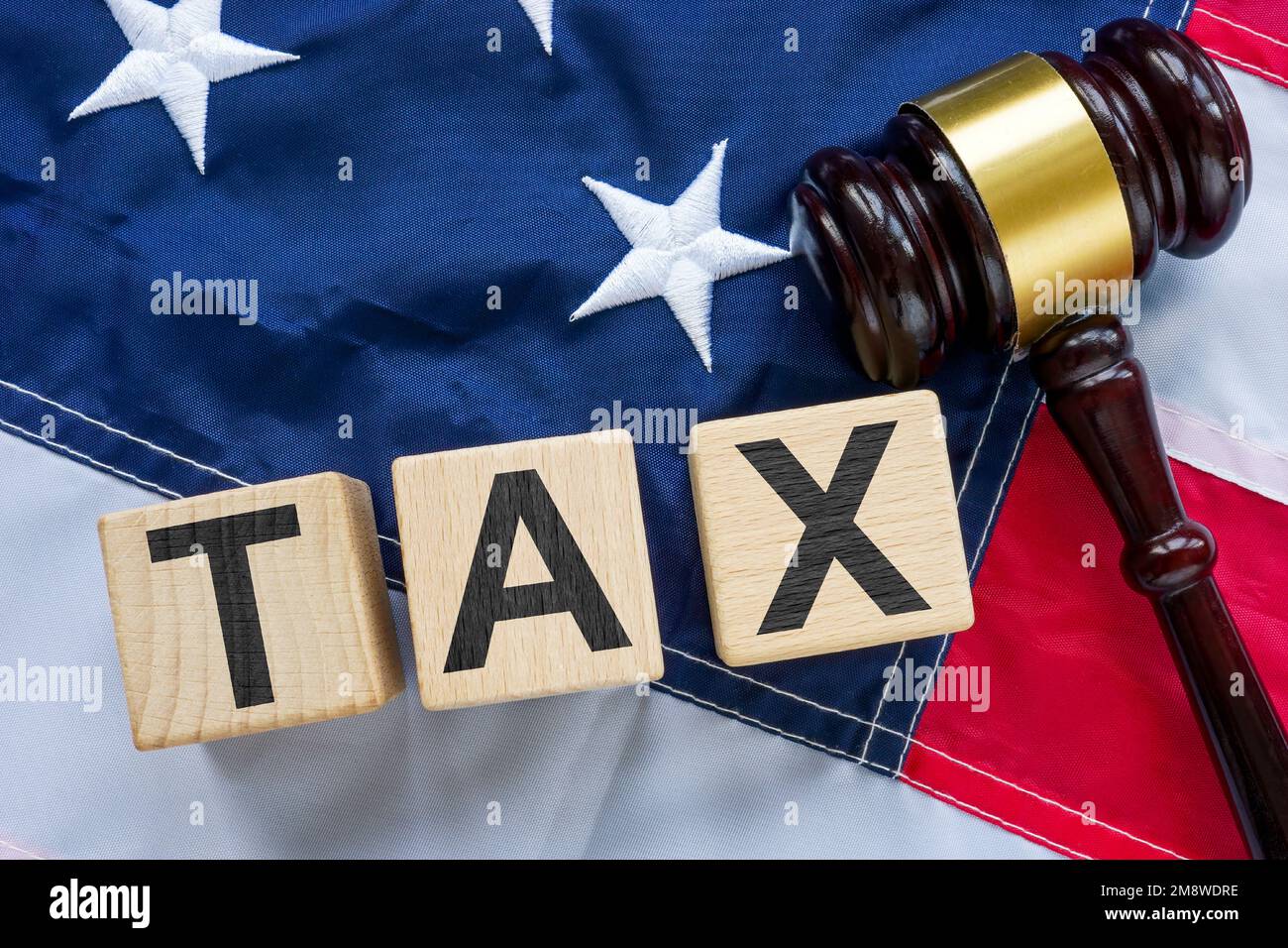 US-Flagge, Hammer und Würfel mit Wortsteuer als Symbol für Steuervermeidung oder Betrug. Stockfoto