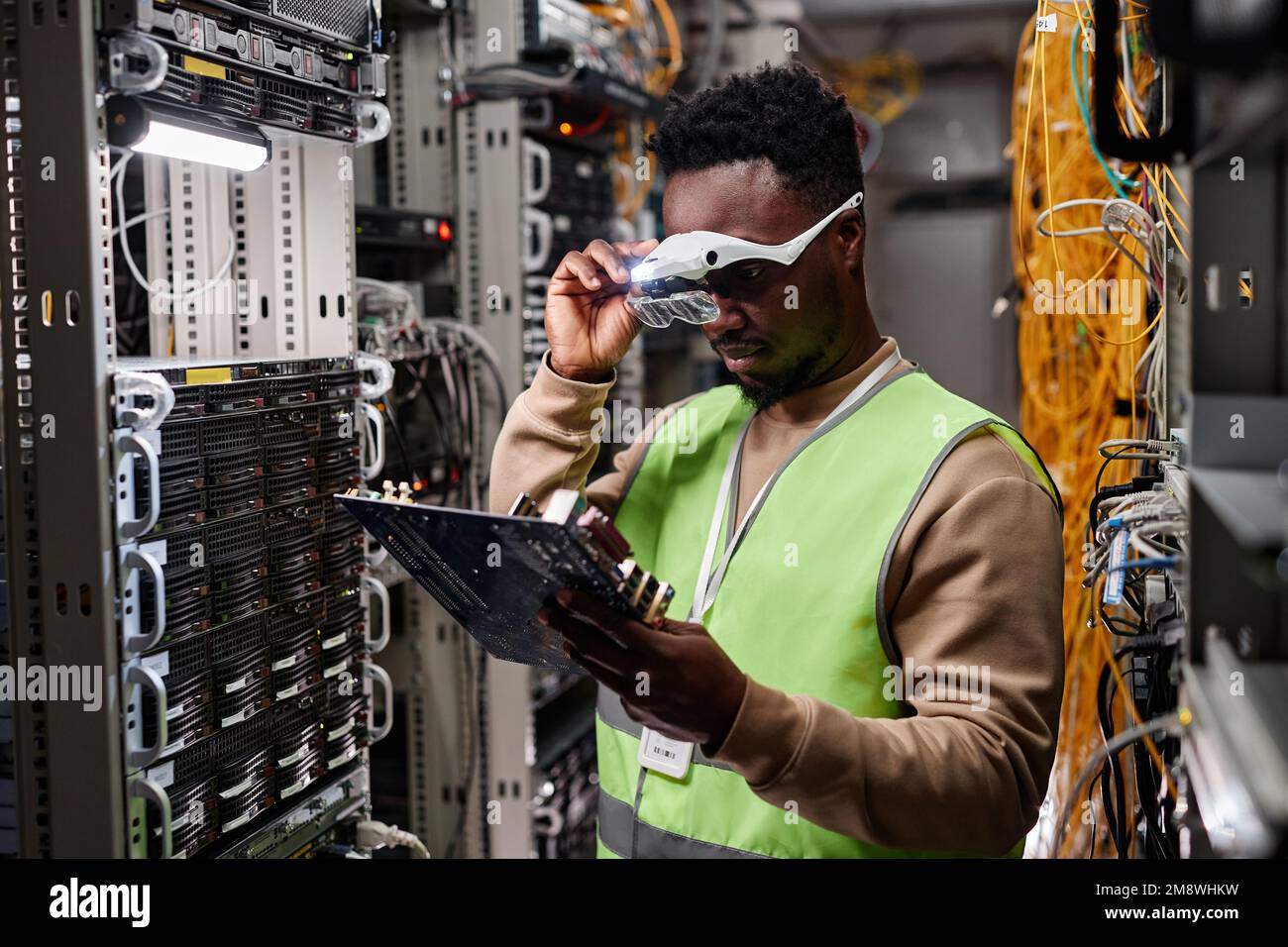 Porträt eines Technikers, der Server im Rechenzentrum repariert und Computerteile untersucht Stockfoto