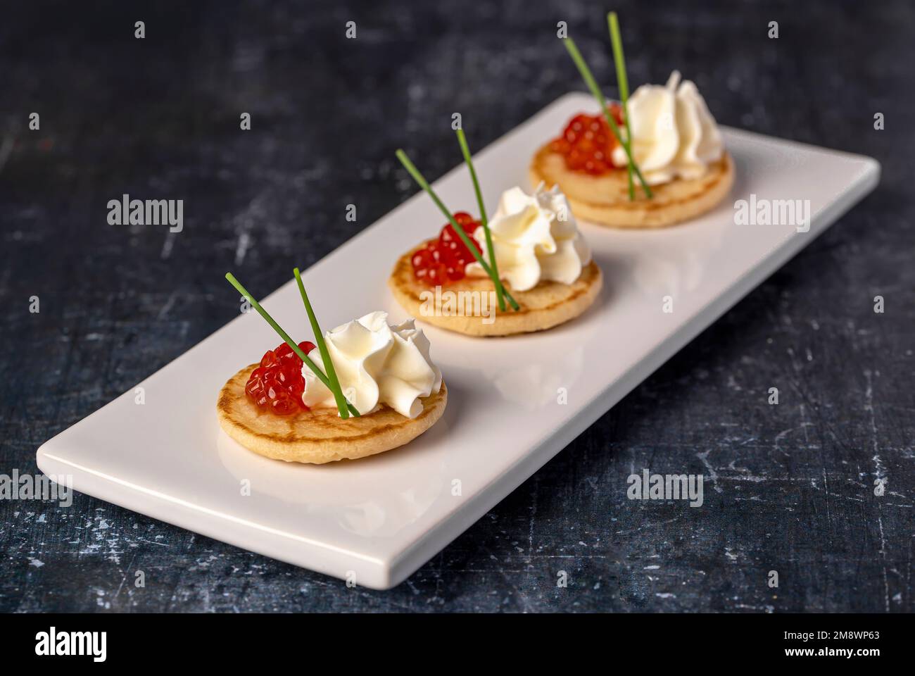 Makro-Food-Fotografie der Vorspeise mit Kaviar, Sahne, Schnittlauch, Imbiss, Meeresfrüchten Stockfoto