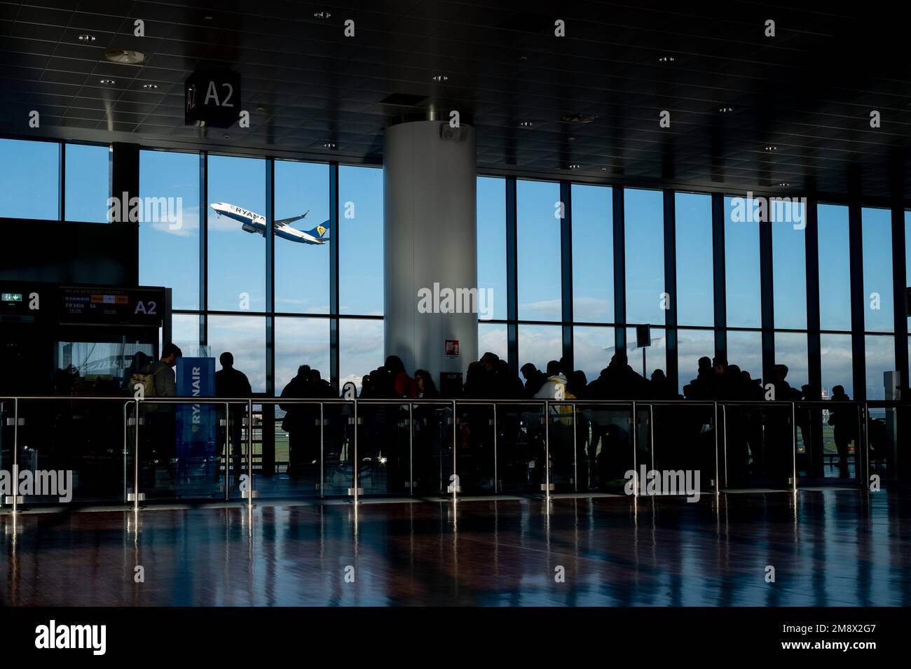 Bergamo (Italien), 9. Januar 2023: Passagiere, die sich am Flugsteig des internationalen Flughafens Caravaggio, besser bekannt als Bergamo Orio al Serio, anstellen. Stockfoto