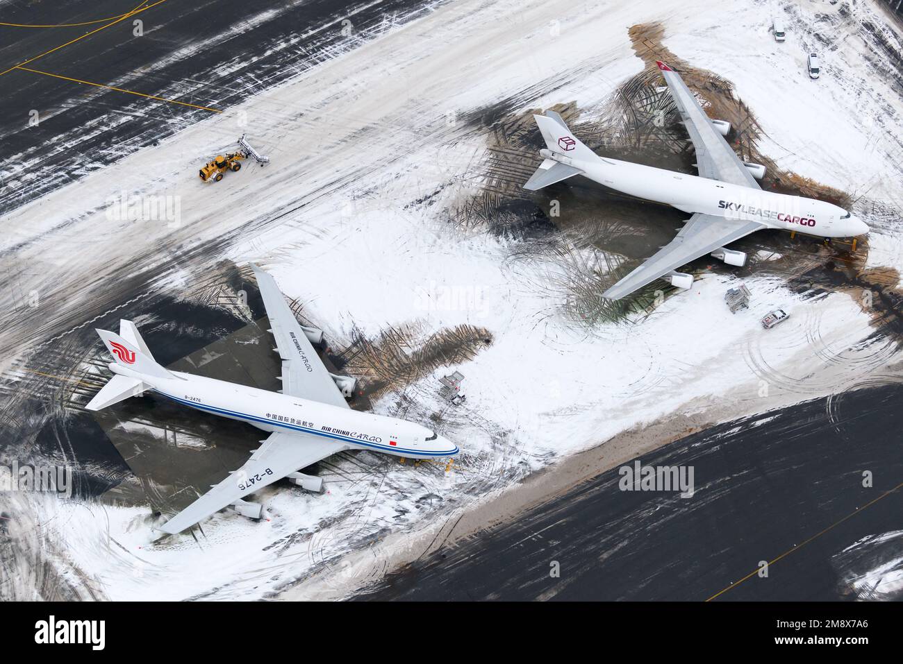 Flughafen Anchorage nach Schneesturm mit zwei Frachtflugzeugen der Boeing 747. Air China Cargo und Sky Lease Cargo 747F Flugzeug im Schneefallbetrieb. Stockfoto