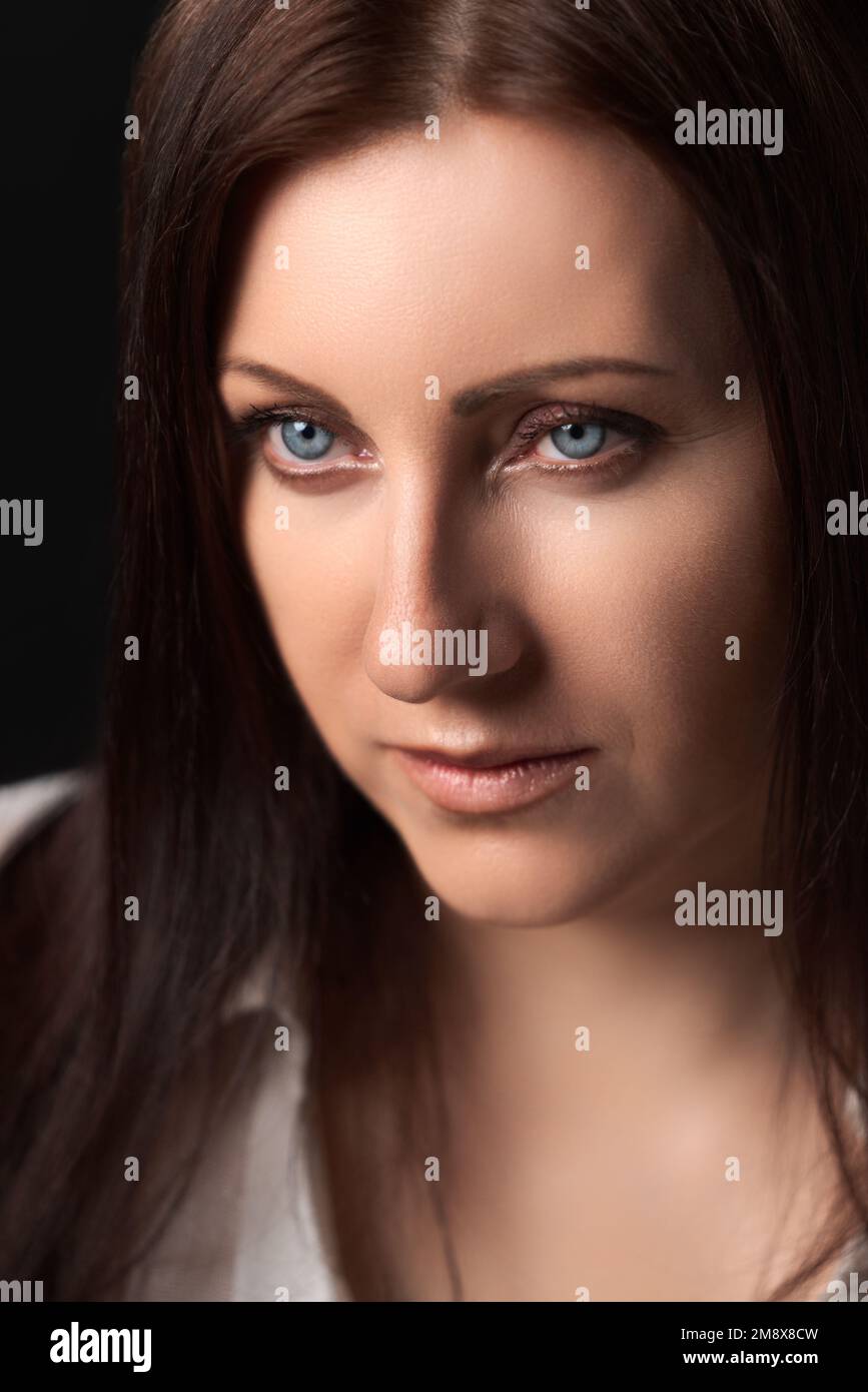Porträt einer kaukasischen, erwachsenen Frau im Alter von 40 Jahren. Hübsches weibliches menschliches Gesicht von Brünette mit grauen Augen Stockfoto