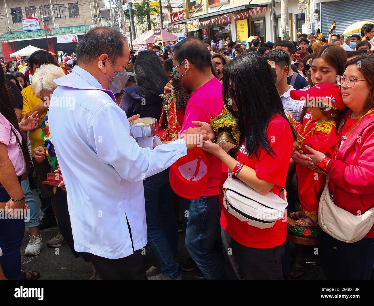 Manila, Philippinen. 15. Januar 2023. Ein katholischer Laienminister gibt den Kirchengästen die Heilige Kommunion. Katholische Anhänger strömen zur Gemeinde Santo Niño de Tondo, auch bekannt als Tondo-Kirche in Manila, mit ihrem Sto. Niño Replikate zu Hause für den Segen. Die älteste katholische Ikone des Landes, der Santo Niño oder der römisch-katholische Titel des Kindes Jesus. Verbunden mit einem religiösen Bild des Christuskindes, das von philippinischen Katholiken weithin als wundersam verehrt wird. (Foto: Josefiel Rivera/SOPA Images/Sipa USA) Guthaben: SIPA USA/Alamy Live News Stockfoto