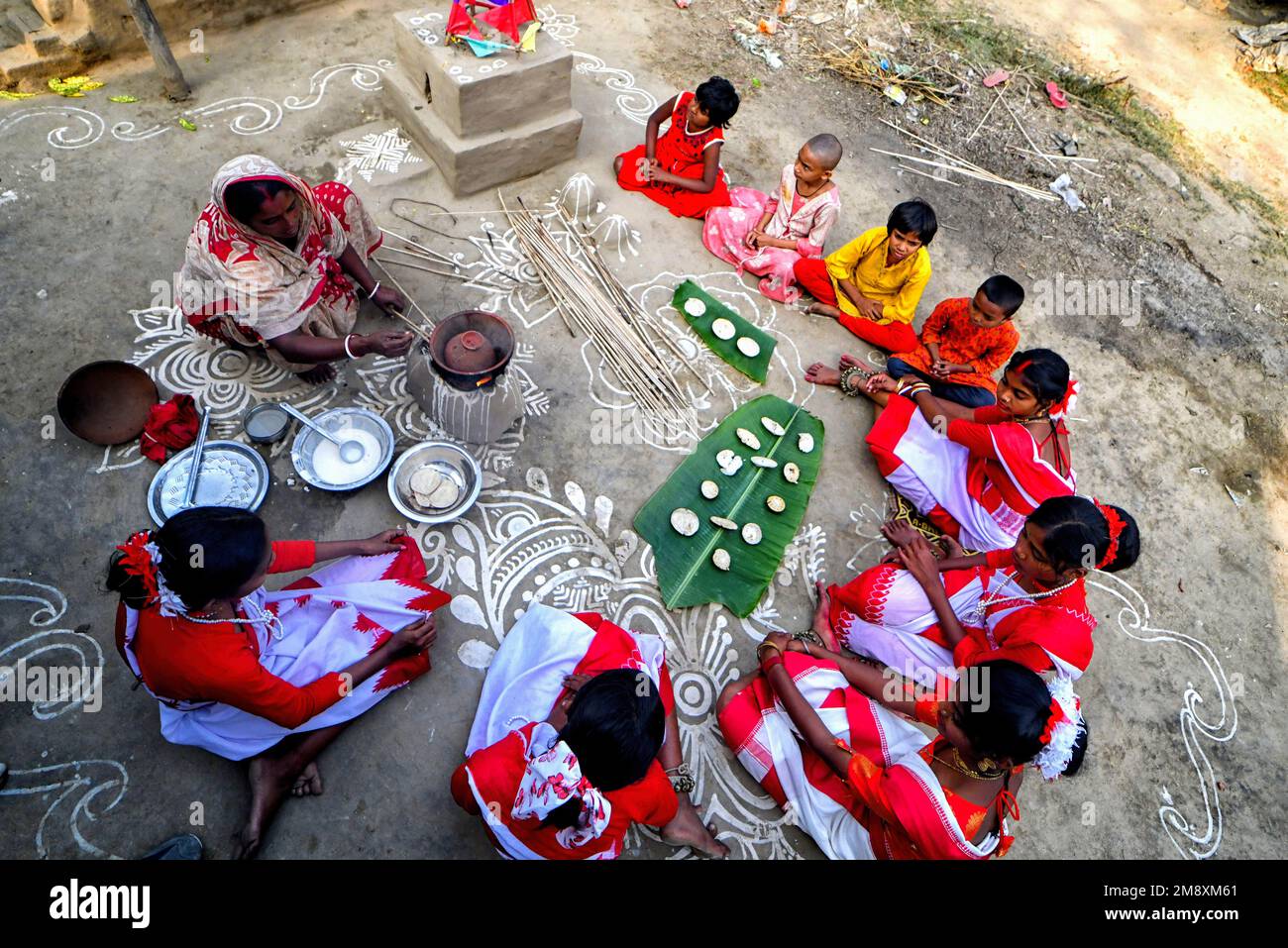 Stammesfrauen haben gesehen, wie sie PiThe zubereitet haben - hergestellt aus Reismehl während des Makar Sankranti (ein wichtiges Festival in Bengal, wenn der Sonnensolf verehrt wird) in einem abgelegenen Dorf von Shantipur. Stammesgemeinde Menschen aus dem ländlichen Bengal Indiens feiern das Tusu Festival am Tag von Makar Sankranti (markiert den Übergang der Sonne vom Sagittarius zum Capricorn) für die letzten 100 Jahre. Dieses Festival wird hauptsächlich von jungen Mädchen gefeiert, die farbenfrohe Chowdal (handgefertigte bunte Gegenstände), dekorative Pflanzen und süße Gerichte namens PiDie im tragen Stockfoto