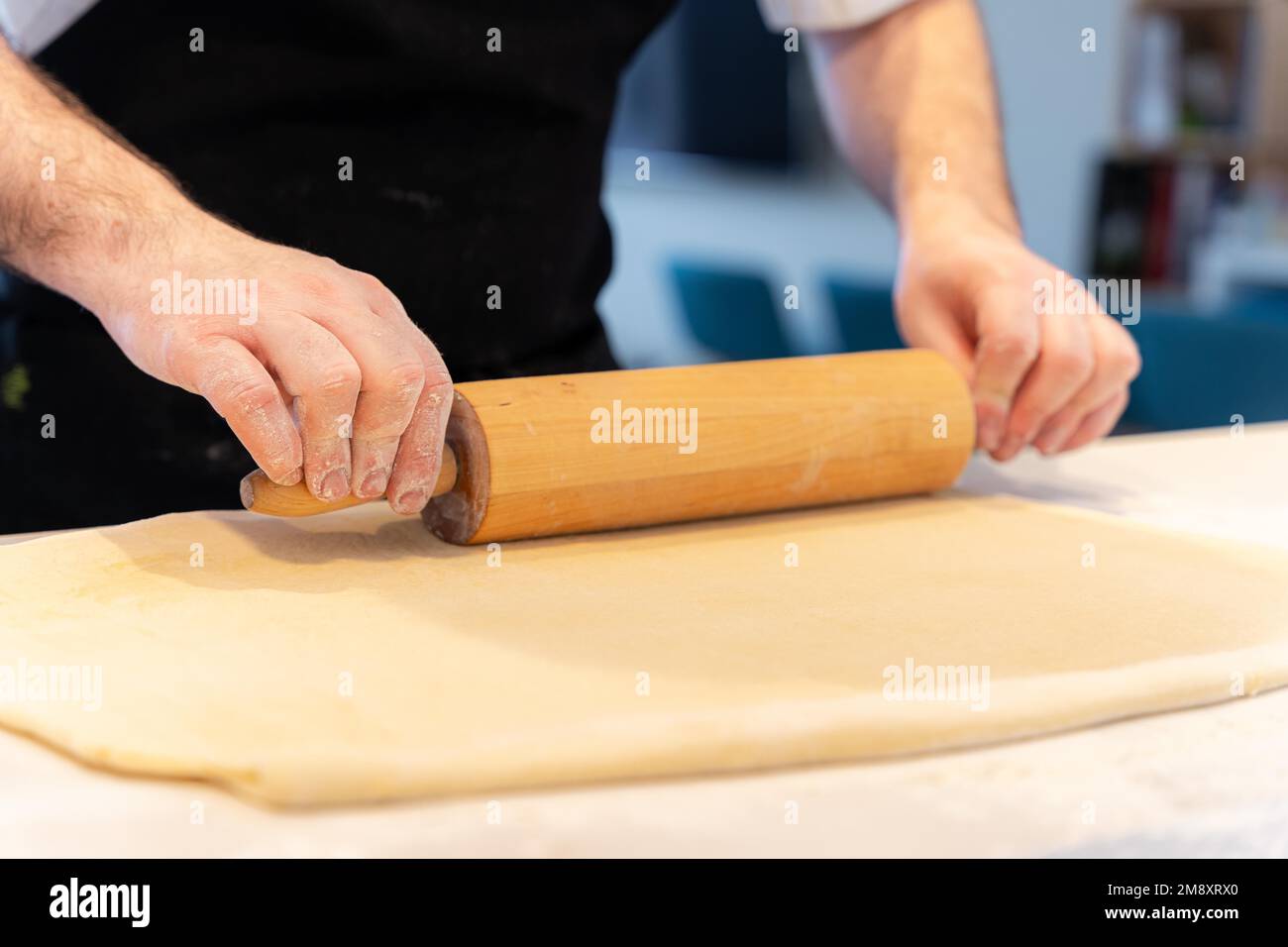 Der Konditor backt selbstgemachte Croissants, knettet Blätterteig mit Werkzeug, arbeitet zu Hause Stockfoto