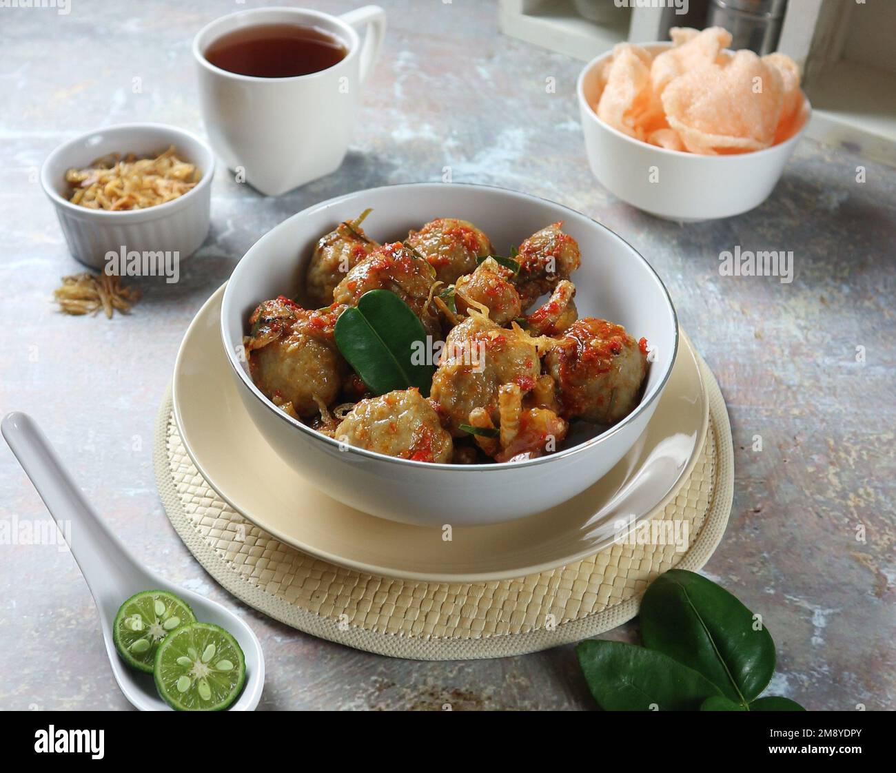 Hähnchenfüße und Fleischbällchen mit würzigen indonesischen Gewürzen, serviert in einer weißen Schüssel Stockfoto