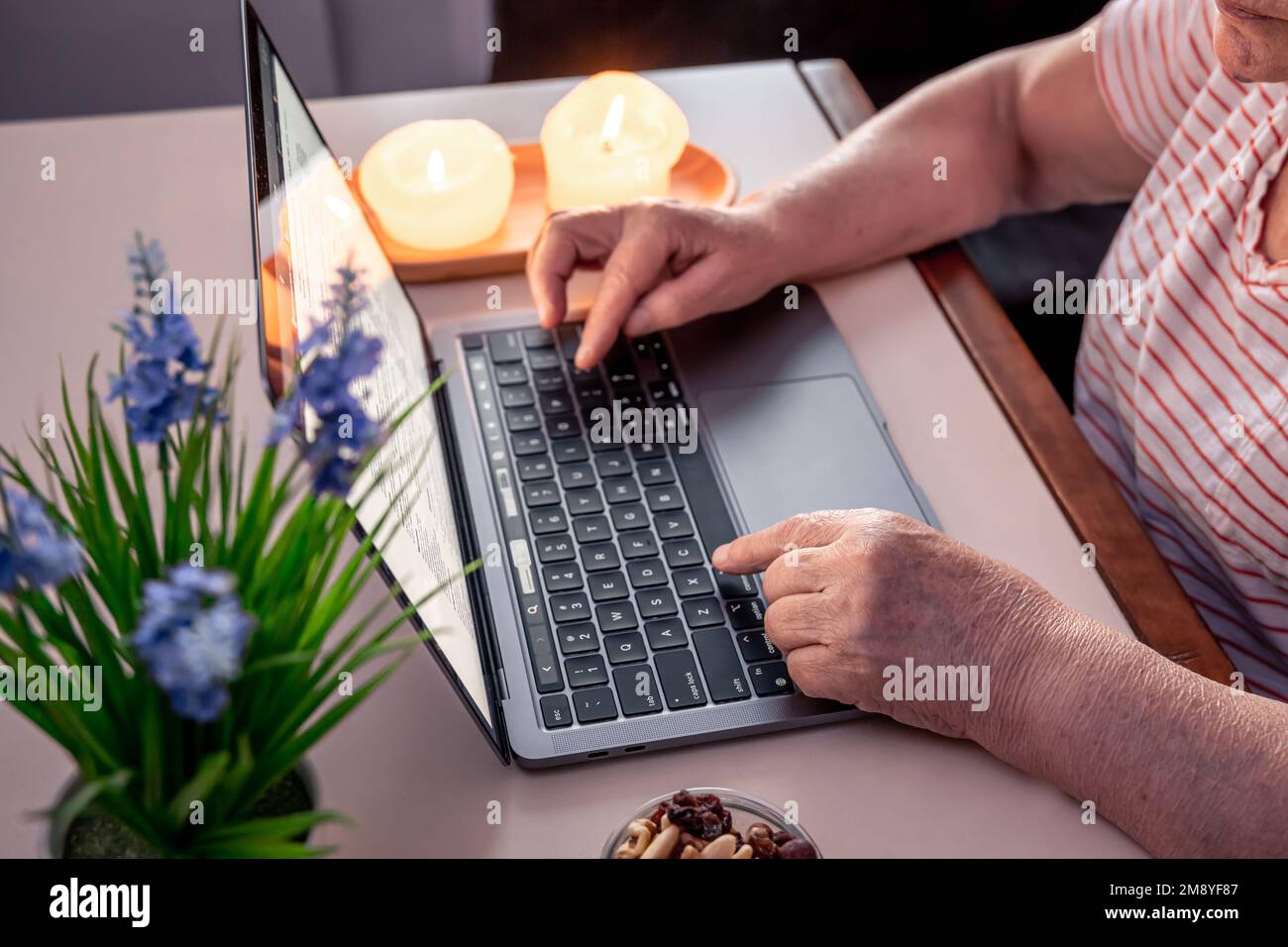 Rentnerin benutzt Laptop, Hände nah dran. Stockfoto