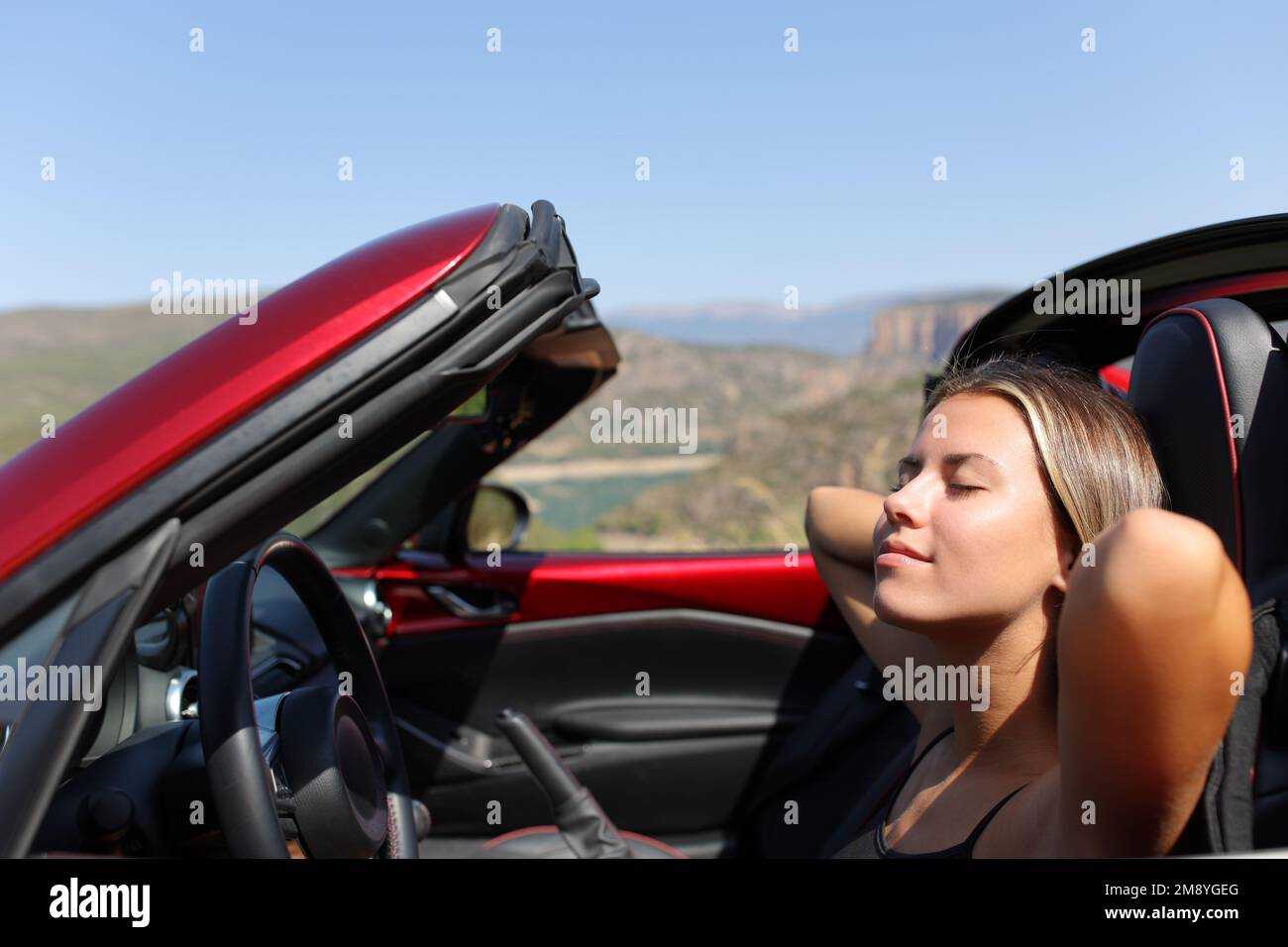 Eine Frau, die sich in einem Cabrio in der Natur entspannt Stockfoto