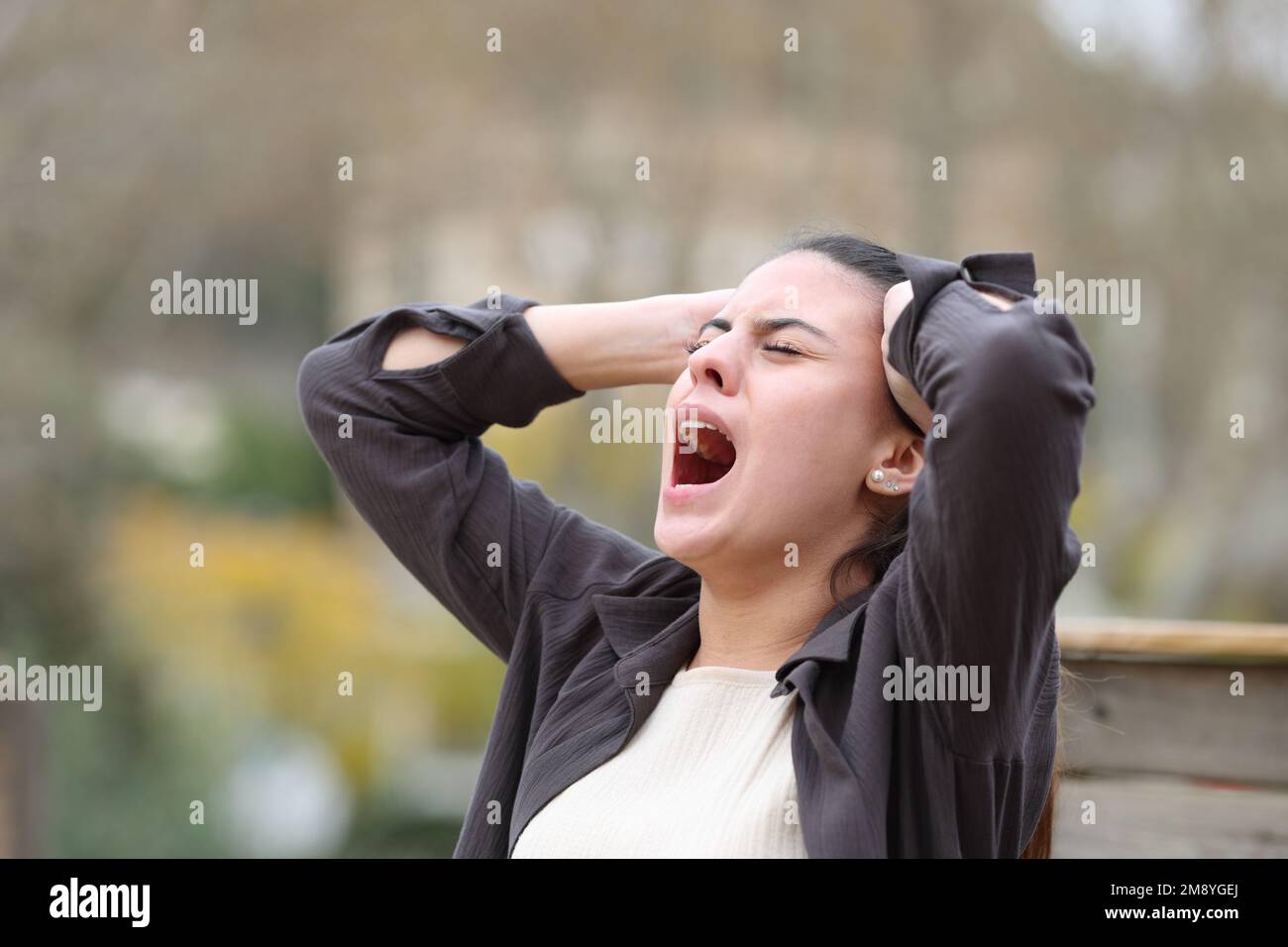 Eine verzweifelte Frau, die allein im Park schreit Stockfoto