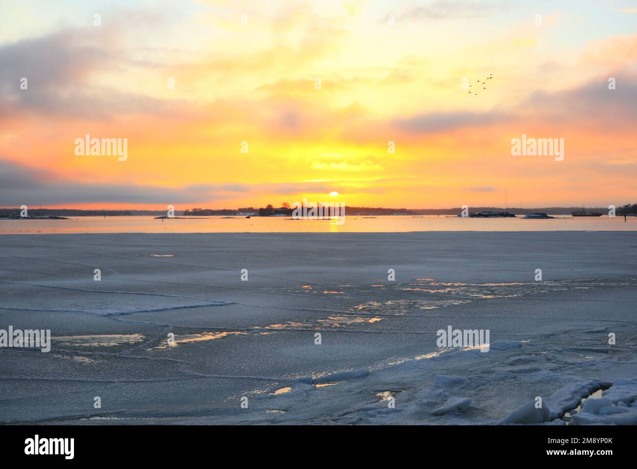 Sonnenaufgang über dem Meer an einem wunderschönen Vormittag Mitte März, mit dem Meer nur noch teilweise eisbedeckt. Der Frühling gewinnt, und die Zugvögel kommen Stockfoto