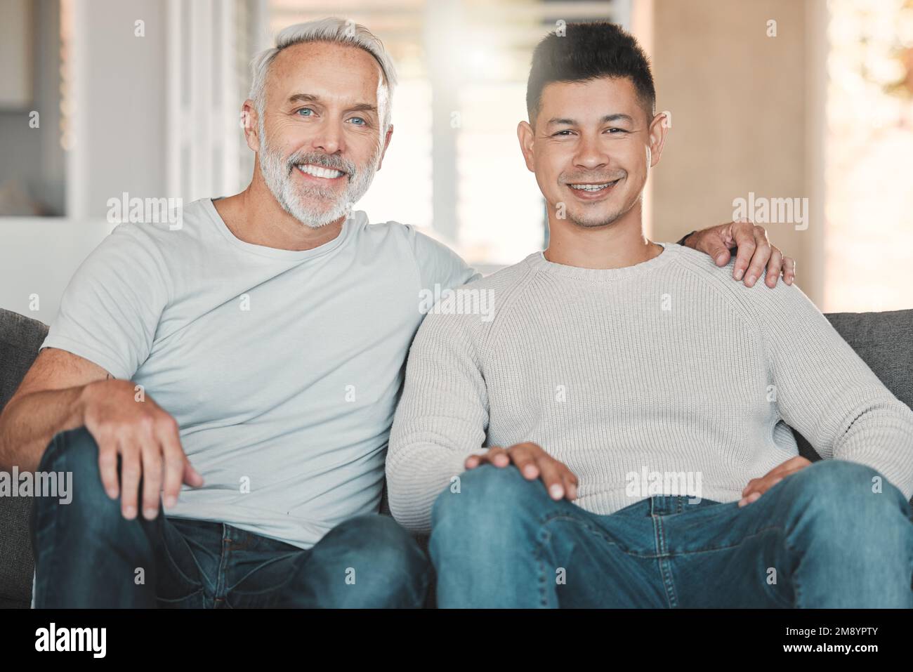 Familie bedeutet, dass niemand zurückgelassen wird. Vater und Sohn sitzen zu Hause auf dem Sofa. Stockfoto