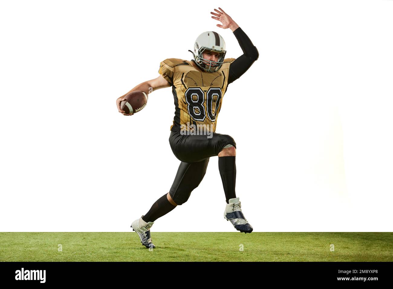 Mann, professioneller american Football-Spieler in Bewegung, Training mit weißem Studiohintergrund. Motivierter Sportler. Sportbegriff, Wettkampf Stockfoto