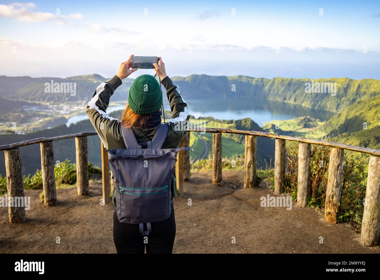Junge Frau, die ein Foto von der malerischen Aussicht auf die Insel São Miguel auf den Azoren macht Stockfoto