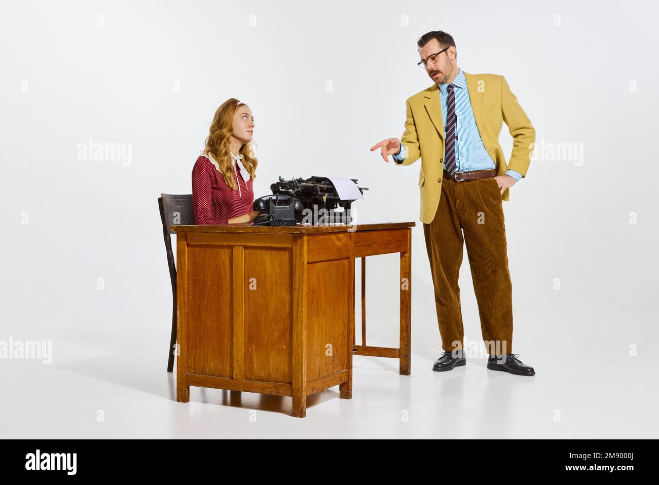 Geschäftsmann, der mit seiner persönlichen Hilfe spricht, weibliche Informationen zu schreiben. Professionelle Notizen zur klassischen Schreibmaschine machen. Geschäftskonzept Stockfoto