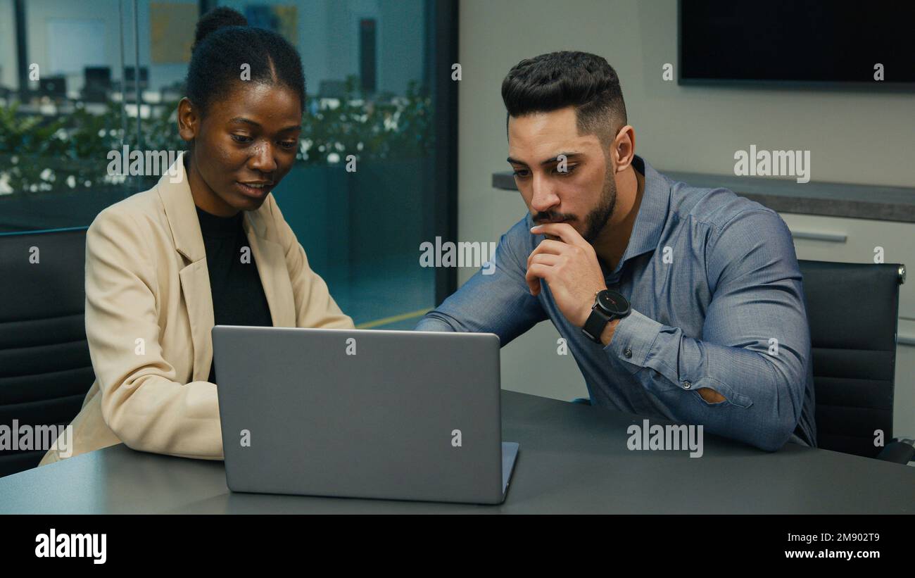 Afroamerikanische Geschäftsfrau Leiterin Experte Mentor Business Coach hilft arabisch-indischen Arbeiter Geschäftsmann mit Online-Fehler mit Laptop zu arbeiten Stockfoto