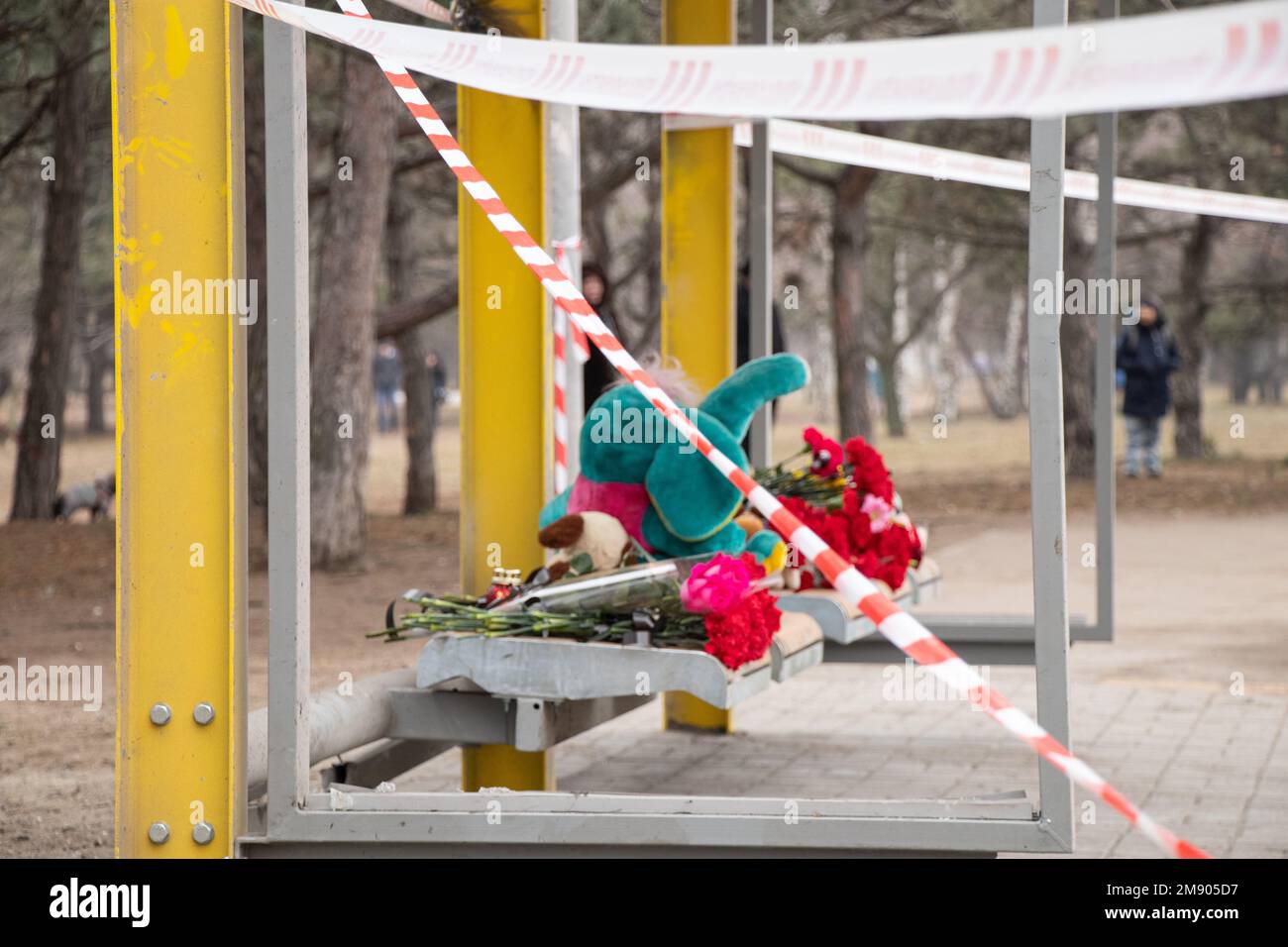 Spielzeug und Blumen liegen an einer Trolleybushaltestelle neben einem Haus, das während des Krieges von einer russischen Rakete auf Pobeda in der Stadt Dnepr in der Ukraine in die Luft gejagt wurde, dem M. Stockfoto