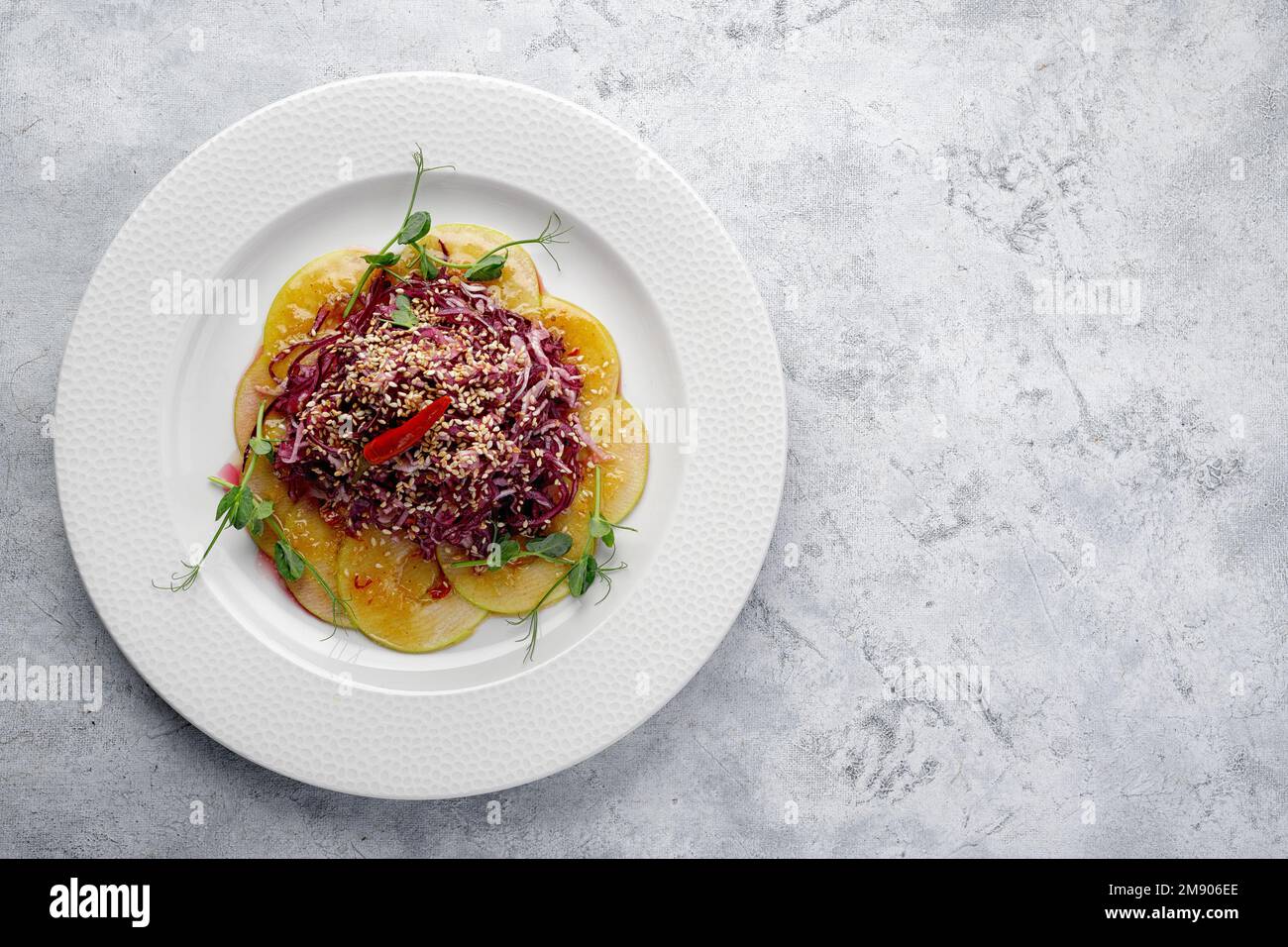 Violetter Kohlsalat mit rotem Pfeffer und Sesamsamen auf hellem Hintergrund Stockfoto