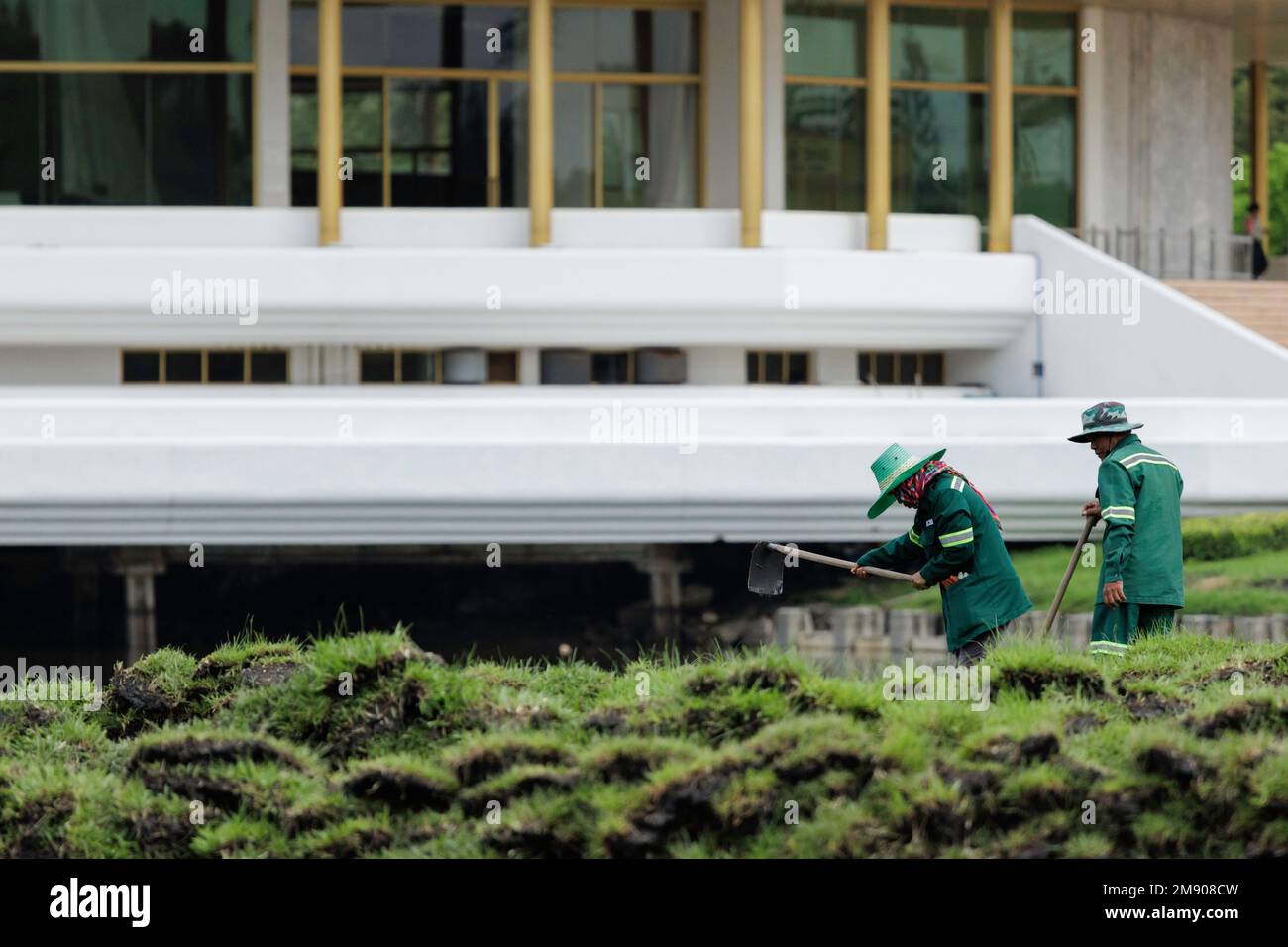 Bangkok, Thailand - 12. Oktober 2020 : Asiatische Gärtnerin, die im Stadtpark Gras anpflanzt und gräbt. Stockfoto