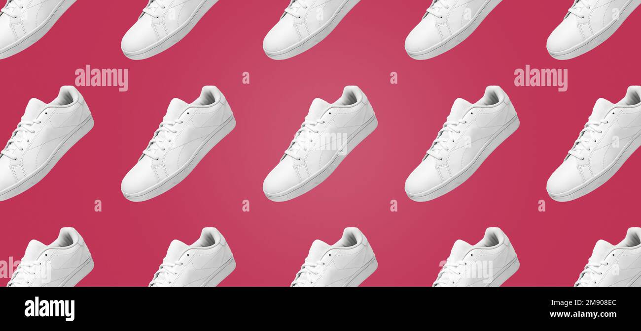 Bannermuster weißer Sneaker isoliert auf Viva Magenta Hintergrund. Sportliches Paar Schuhe für Mockup. Modische, stylische sportliche Freizeitschuhe. Stockfoto