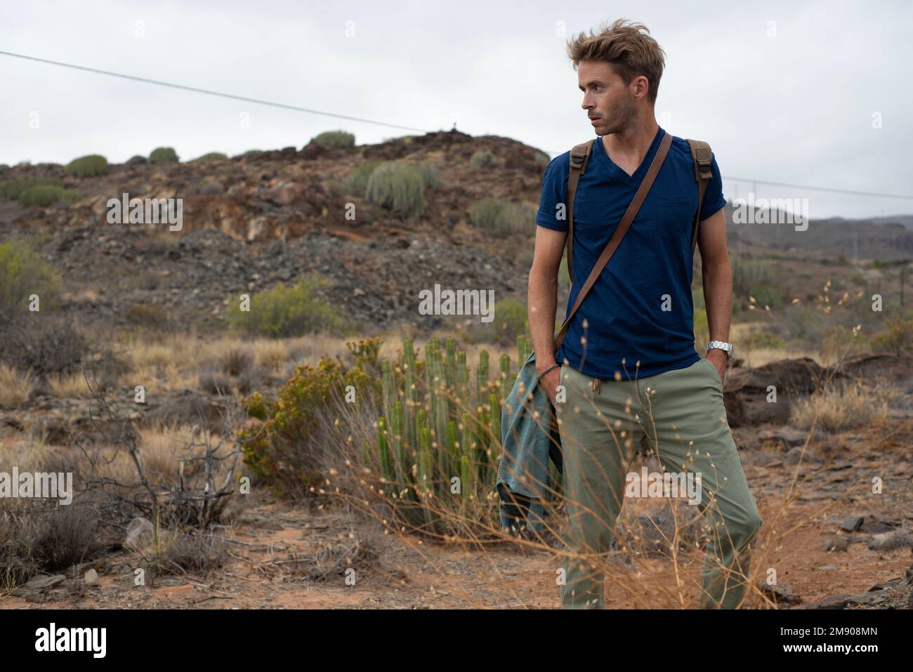 Der junge, gutaussehende Tourist läuft mit seinem Rucksack aufs Feld. Natururlaub. Stockfoto