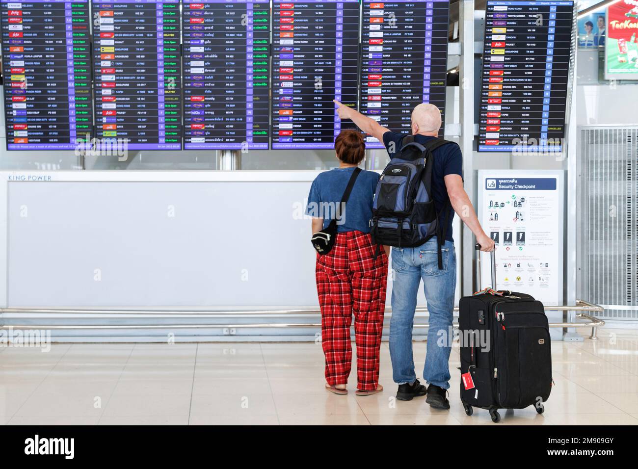 Bangkok, Thailand - 18. Januar 2023 : Reisende mit Gepäck, die auf der Abflugplantafel zum Check-in am suvarnabhumi airpo schauen Stockfoto
