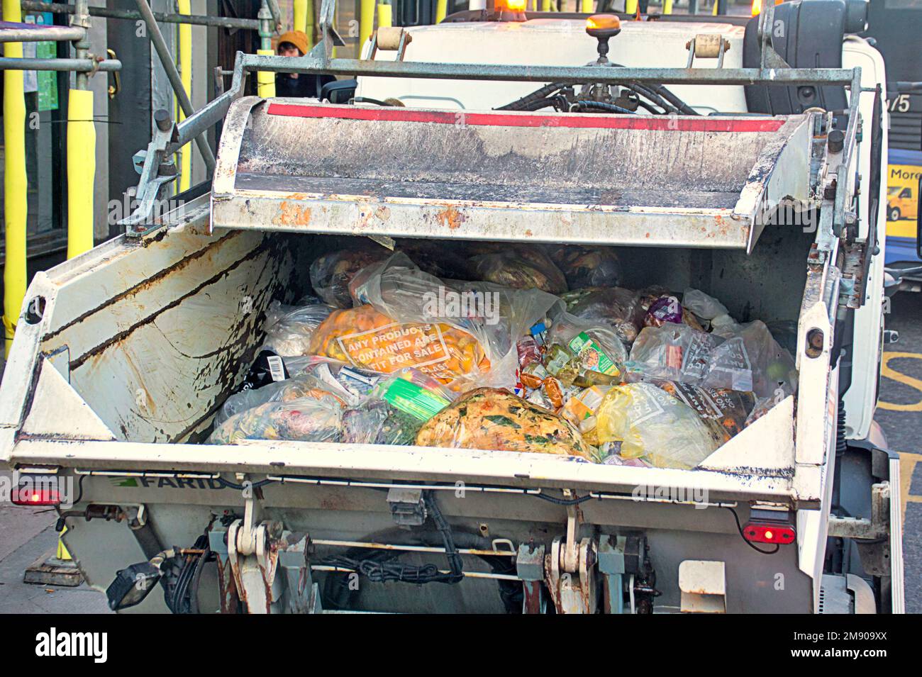 Gewerblicher Müllwagen mit Inhalt des Müllbehälters, der Lebensmittel aus der Mitnahme und Restaurants aus dem Recycling enthält Stockfoto