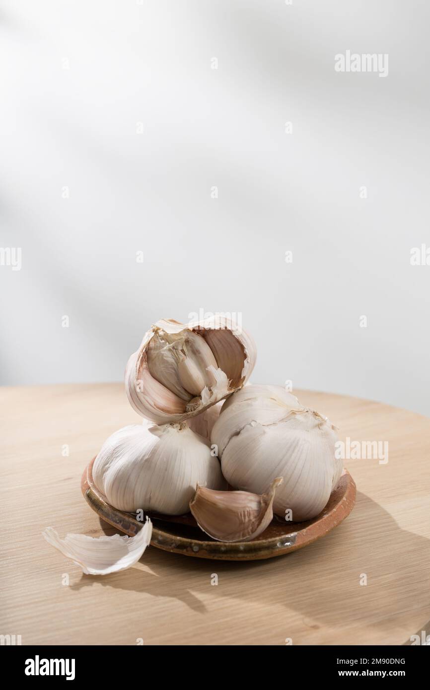 Knoblauch auf einem kleinen Teller auf einem Holztisch Stockfoto