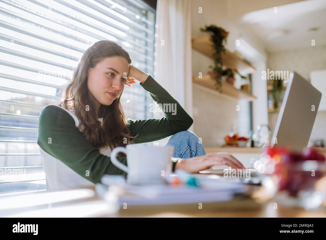 Junge Frau, die Hausaufgaben in ihrer Wohnung hat. Stockfoto