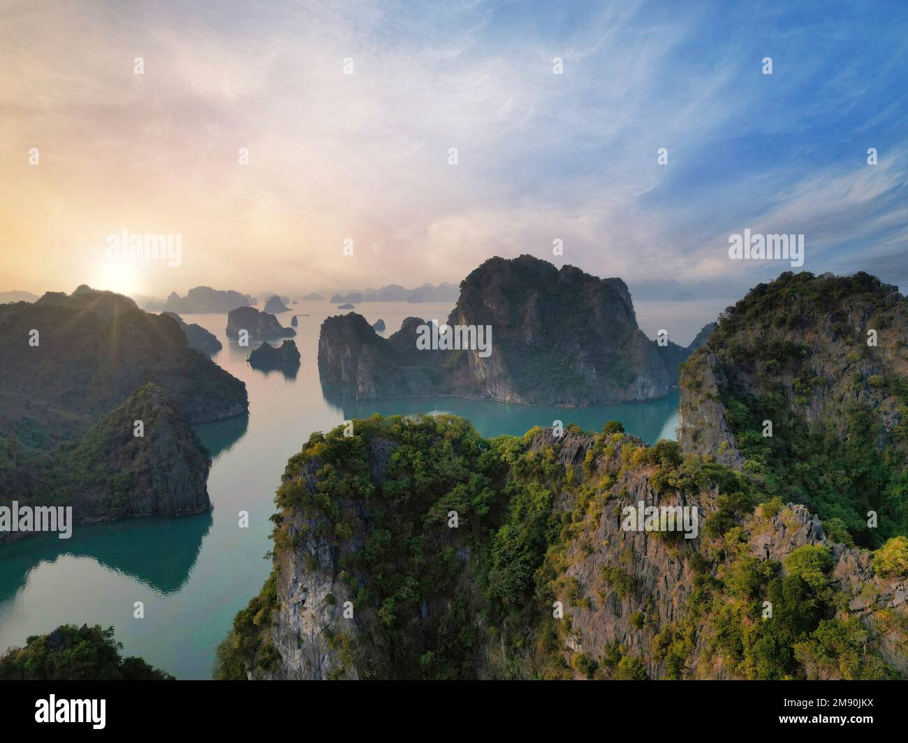Verträumt Sonnenuntergang unter den Felsen der Halong Bay, Vietnam Stockfoto