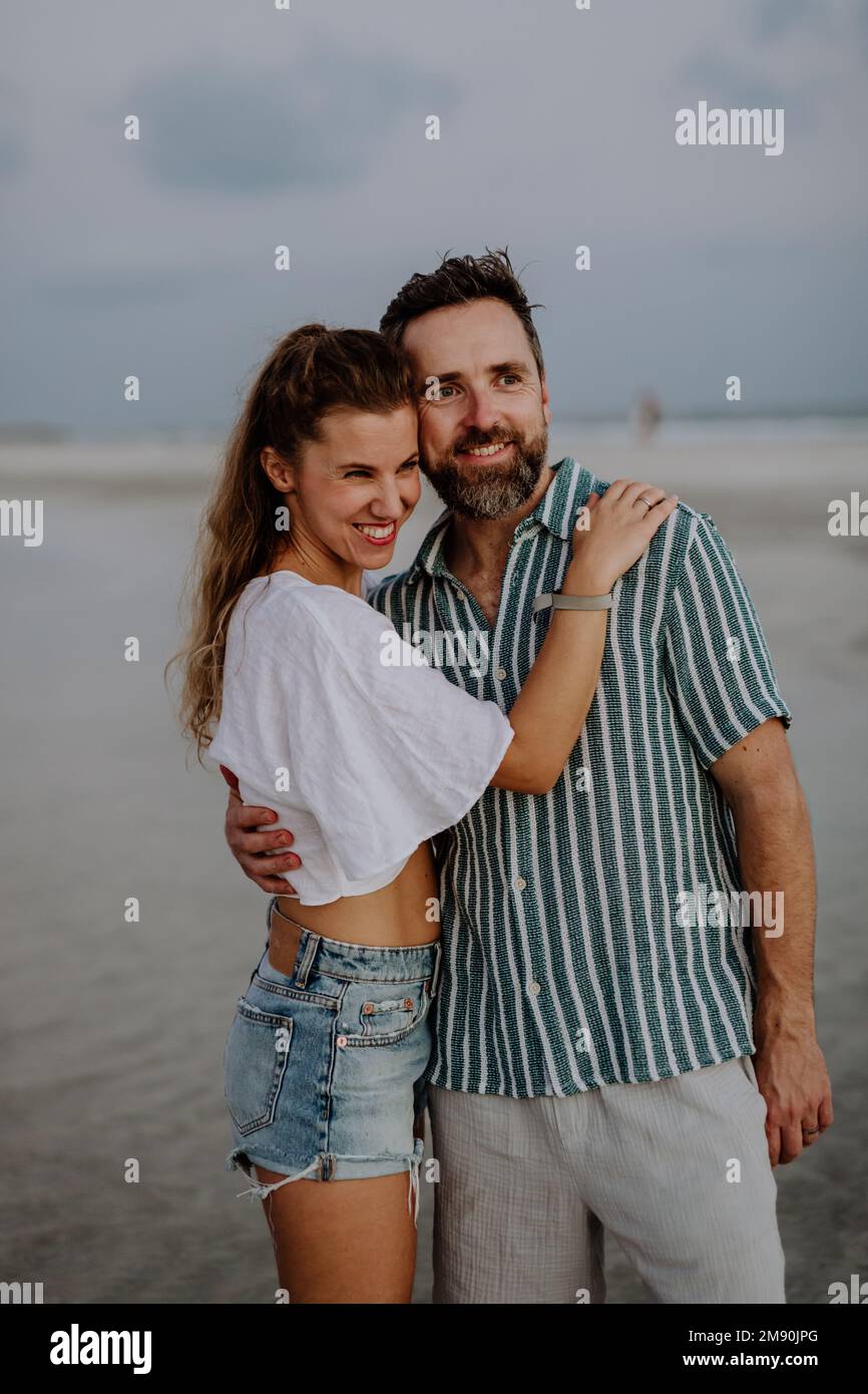 Porträt eines glücklichen Paares, das zusammen auf das Meer schaut. Stockfoto
