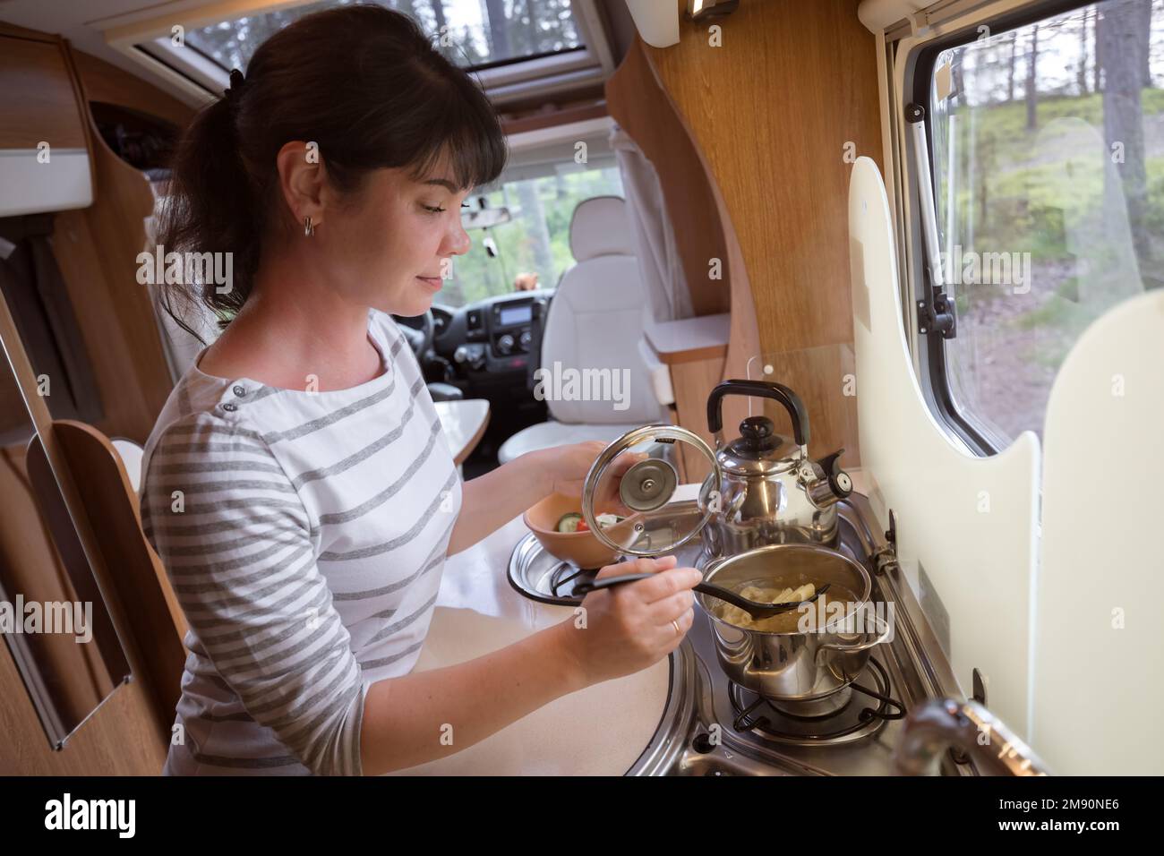 Frau kochen in Reisemobil, Wohnmobil RV Interieur. Familie Urlaub Reisen, Urlaub im Reisemobil, Caravan Auto Urlaub. Stockfoto Frau kochen in Reisemobil, Wohnmobil RV Interieur. Familie Urlaub Reisen, Urlaub im Reisemobil, Caravan Auto Urlaub. Stockfoto
