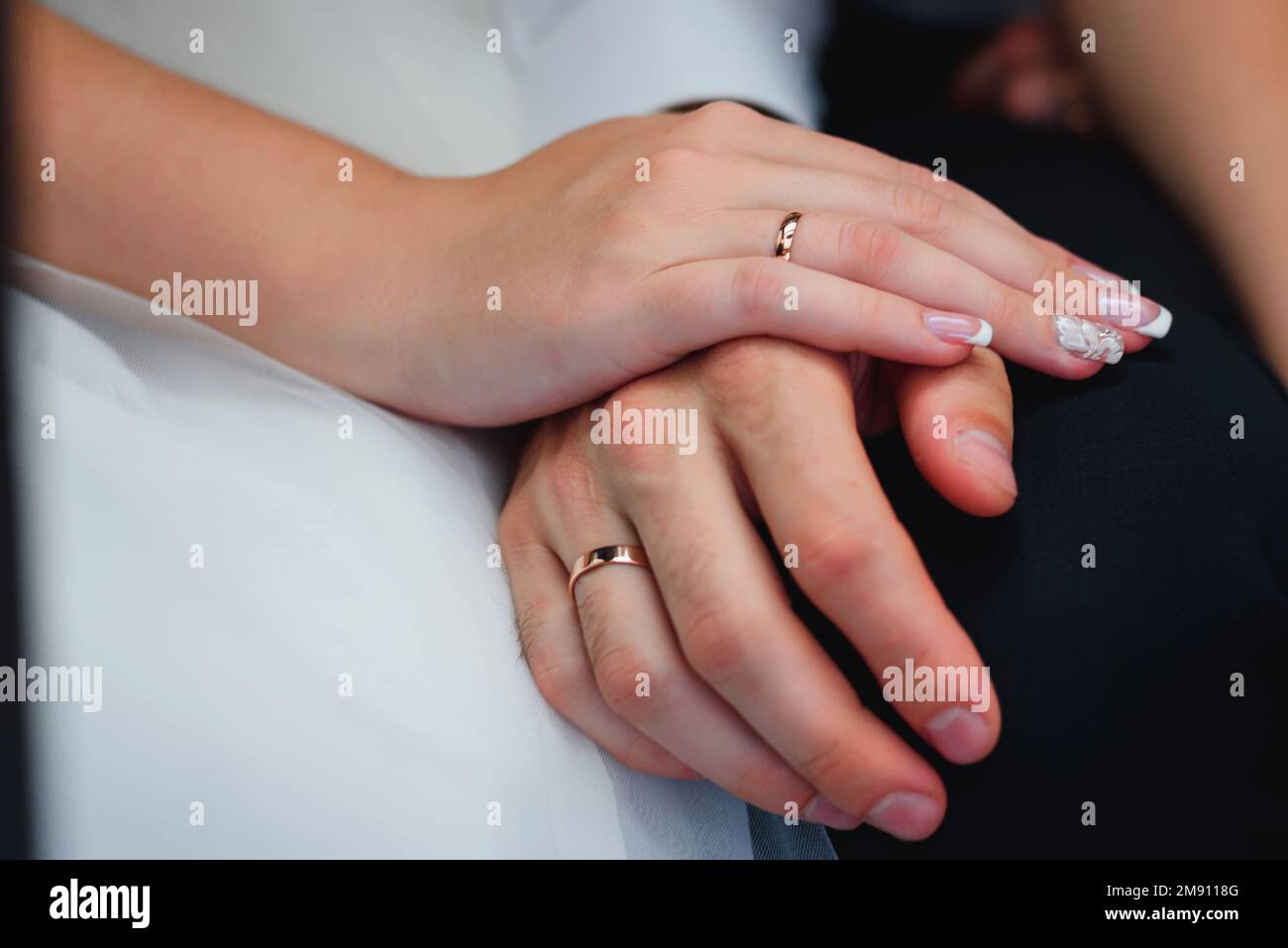 Die Hände von frisch Vermählten, die sich in goldene Ringe verlieben, bei der Hochzeitsschließung Stockfoto