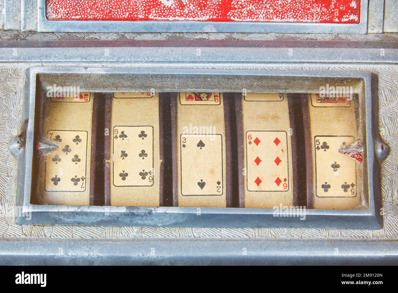 Retro-Bild einer Nahaufnahme eines verwitterten alten Spielautomaten mit Spielkarten Stockfoto
